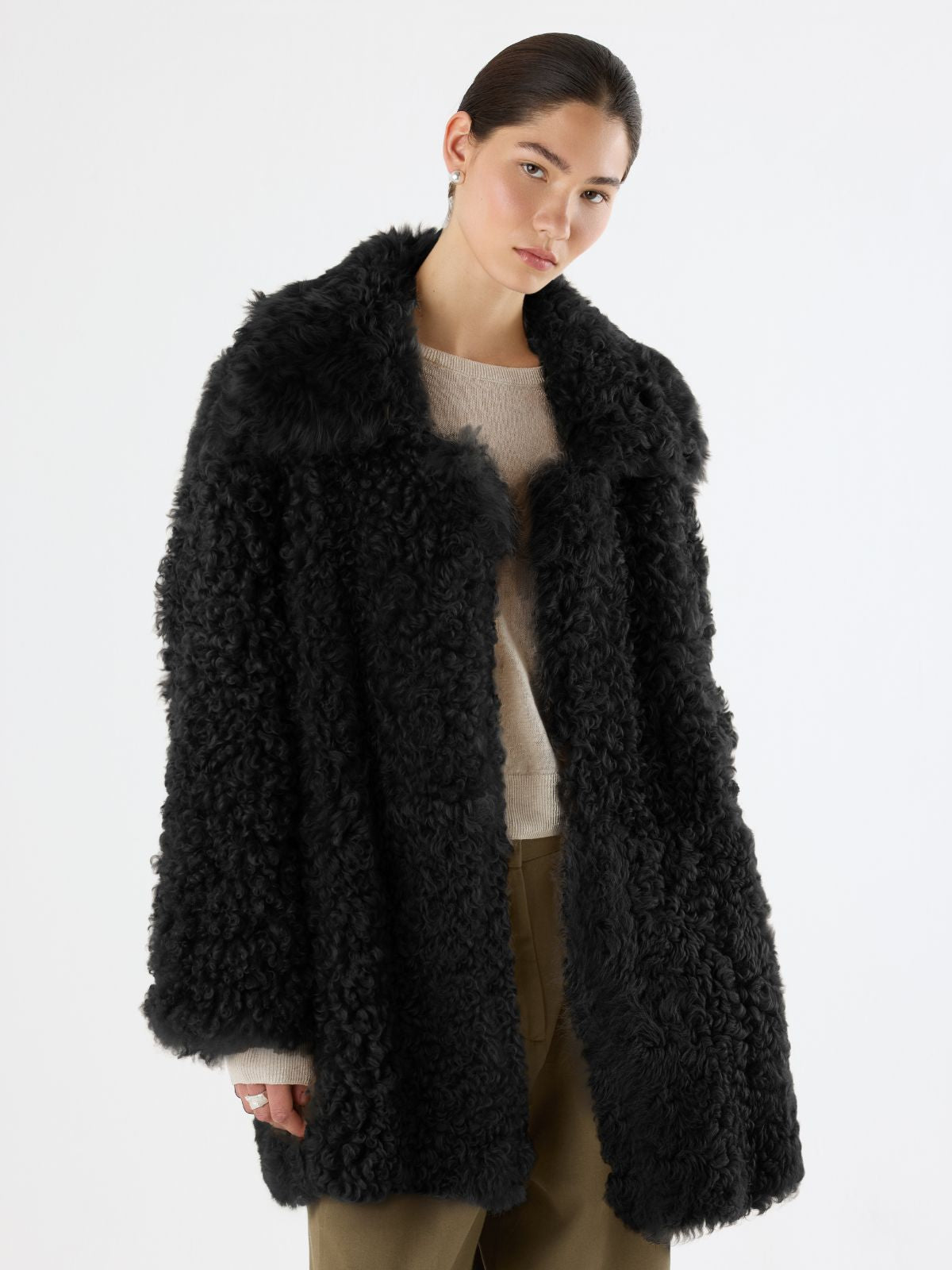 woman wearing Black Relaxed Fit Curly Shearling Coat by Gushlow & Cole over green trousers