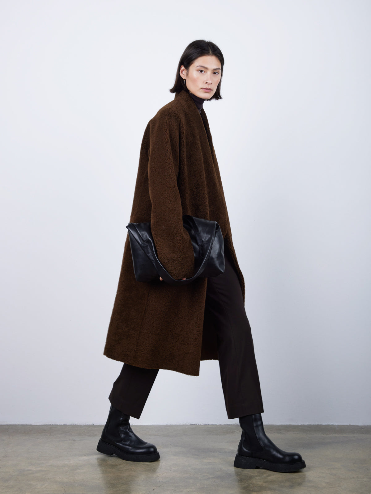 Brown Collarless Shearling Wrap Coat | Womens | Gushlow & Cole - model side with bag