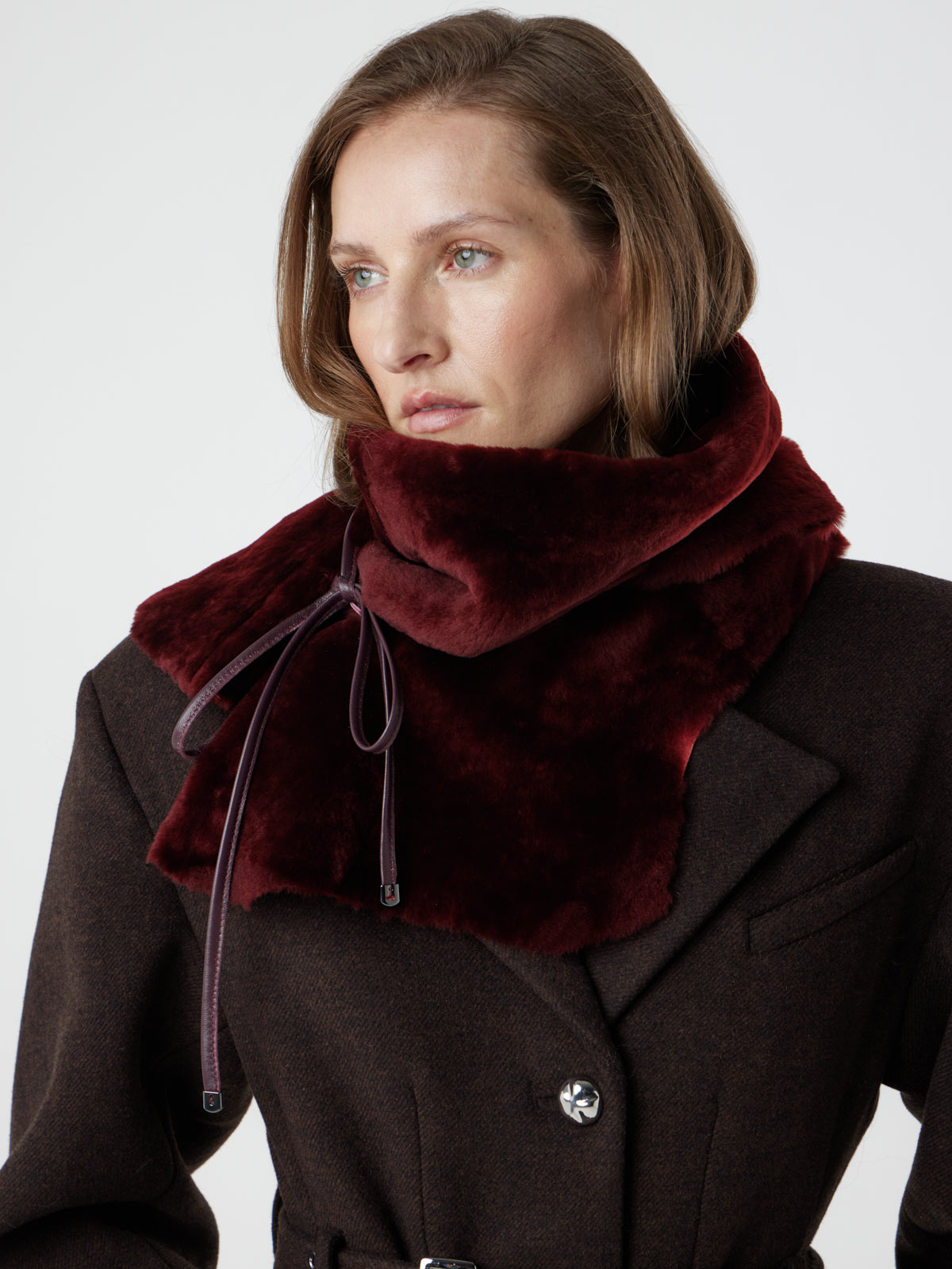 woman wearing cherry red shearling shawl scarf by gushlow & cole, tied as a snood