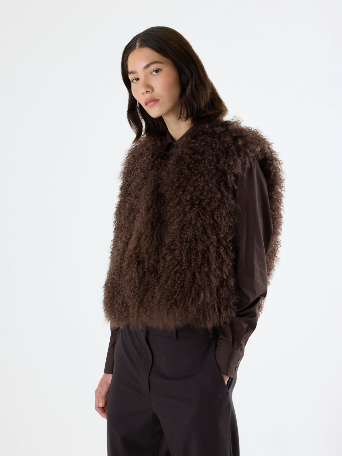 side view of woman wearing conker brown Mongolian Shearling Gilet by gushlow & Cole