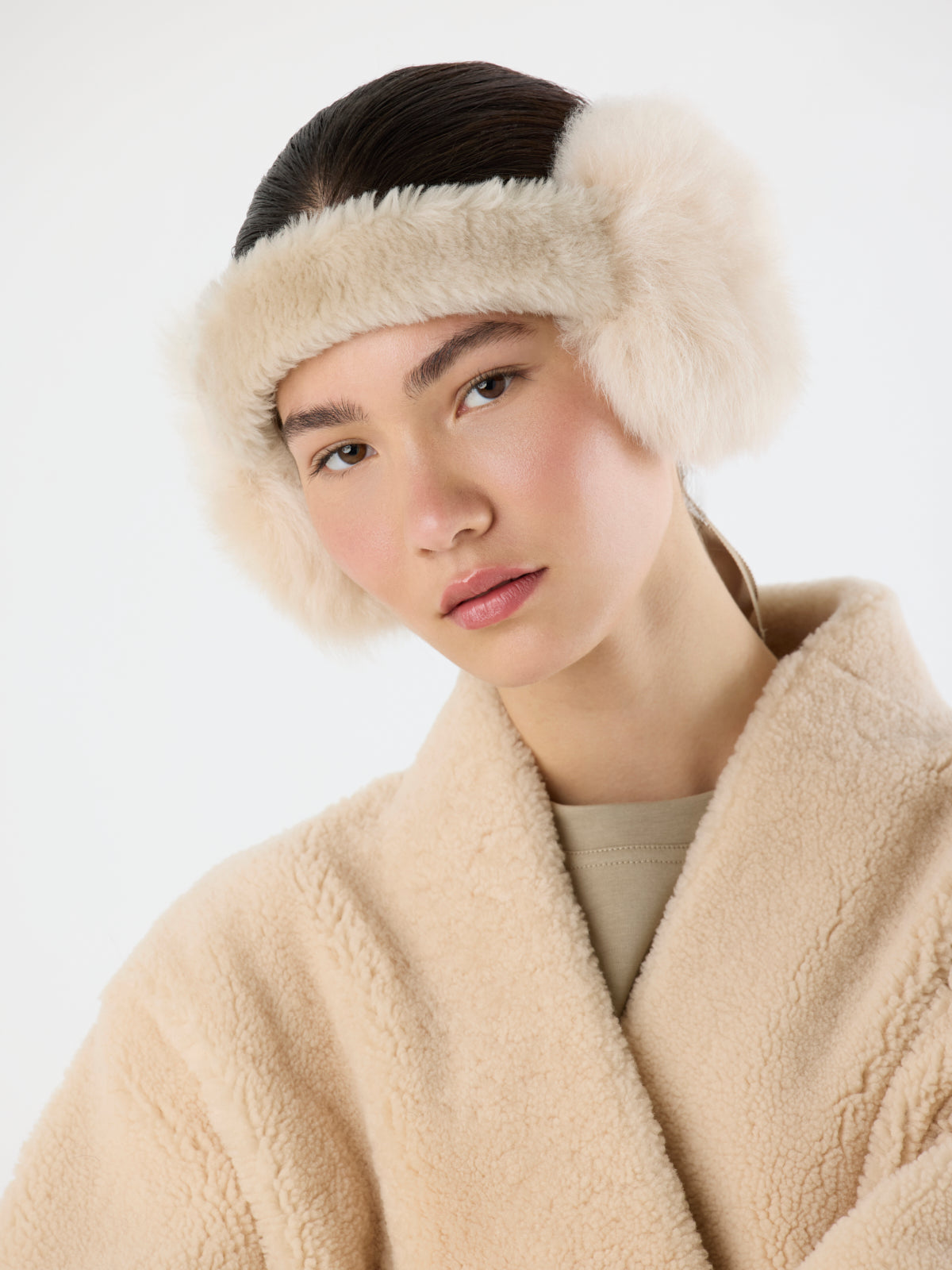 woman wearing cream Tied Shearling Ear Muffs by gushlow & cole