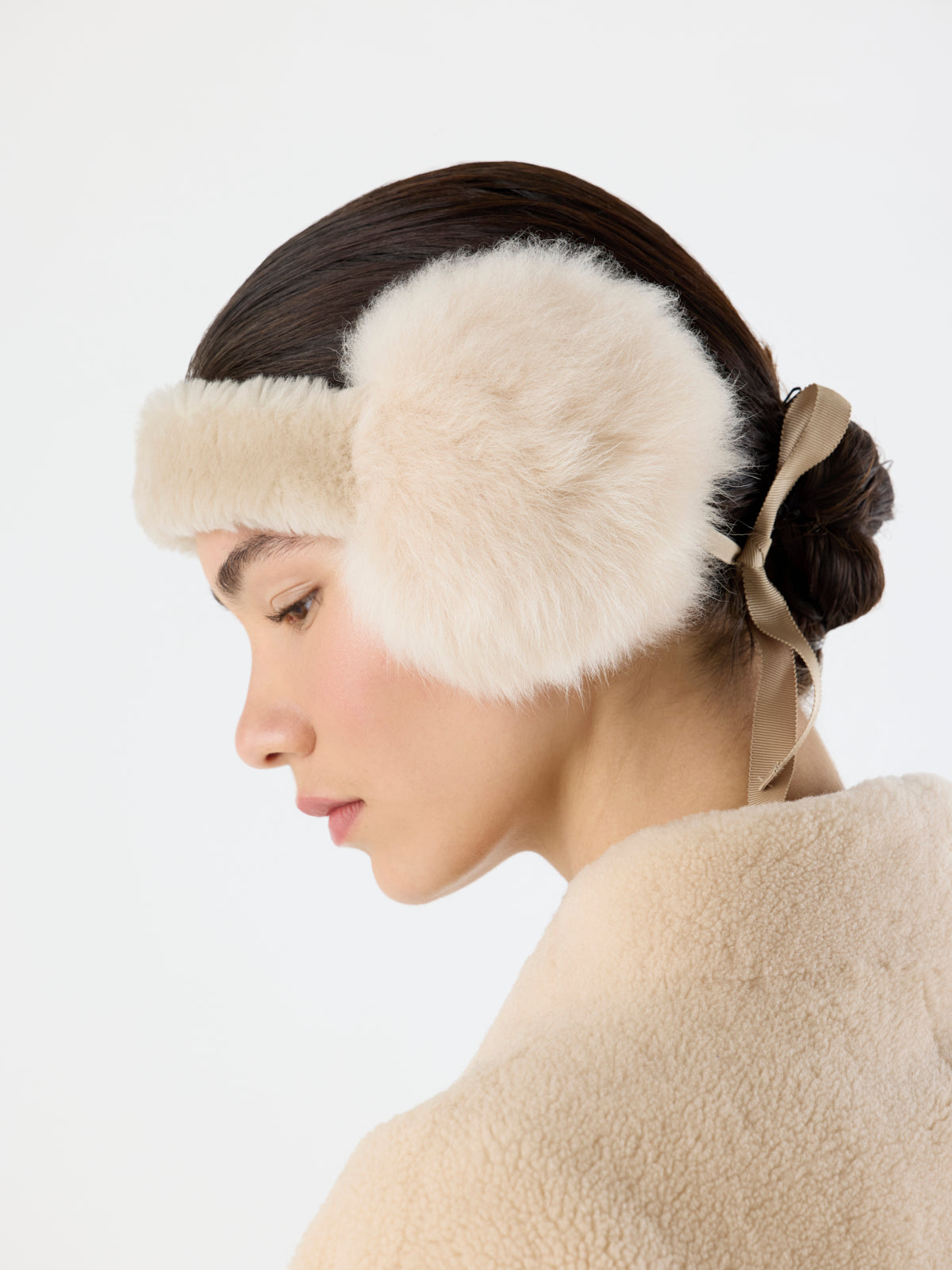 side view of woman wearing cream Tied Shearling Ear Muffs by gushlow & cole