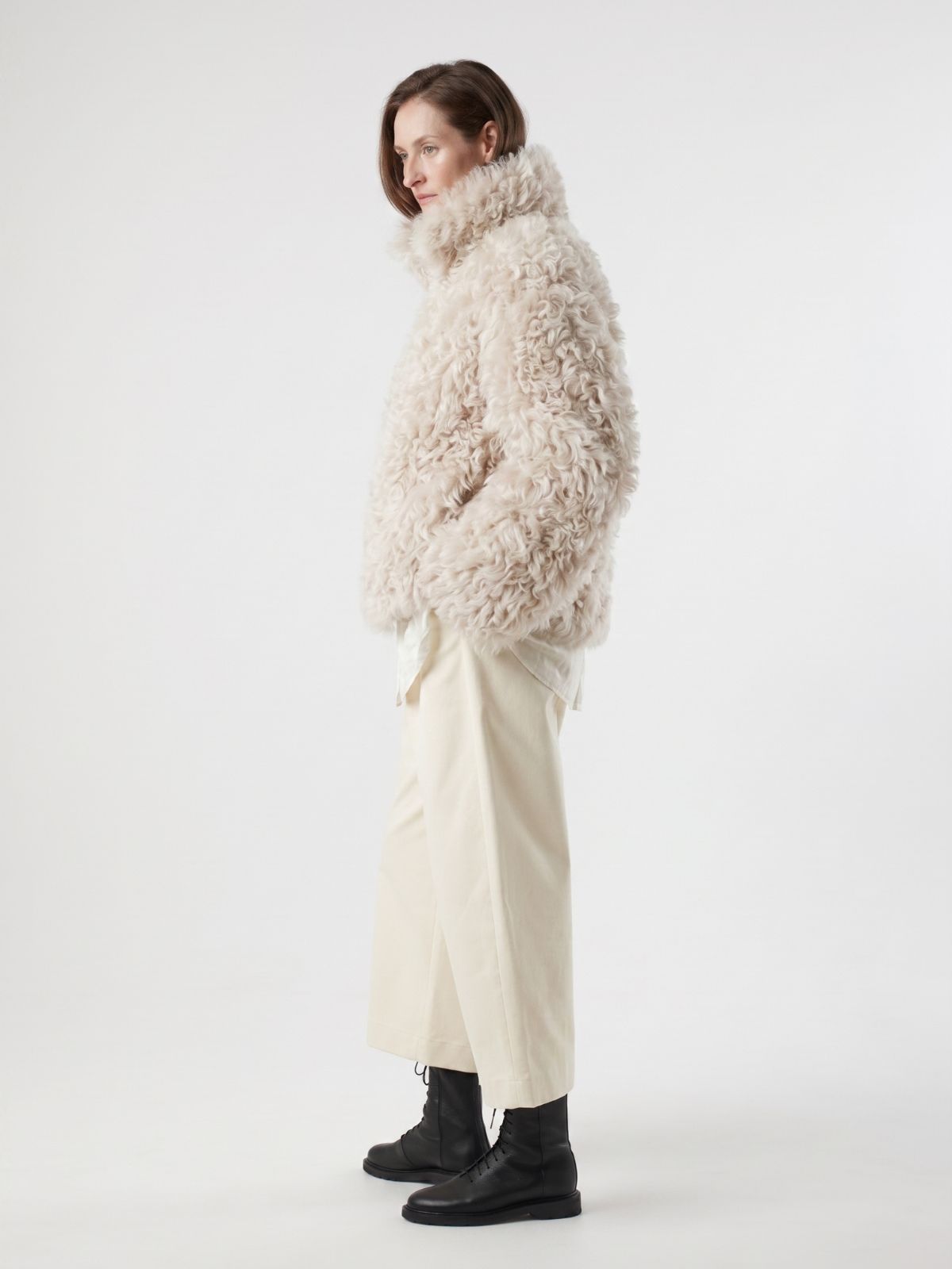 side view of woman wearing Cream Relaxed Fit Curly Shearling Jacket by gushlow & cole / curly sheepskin Jacket