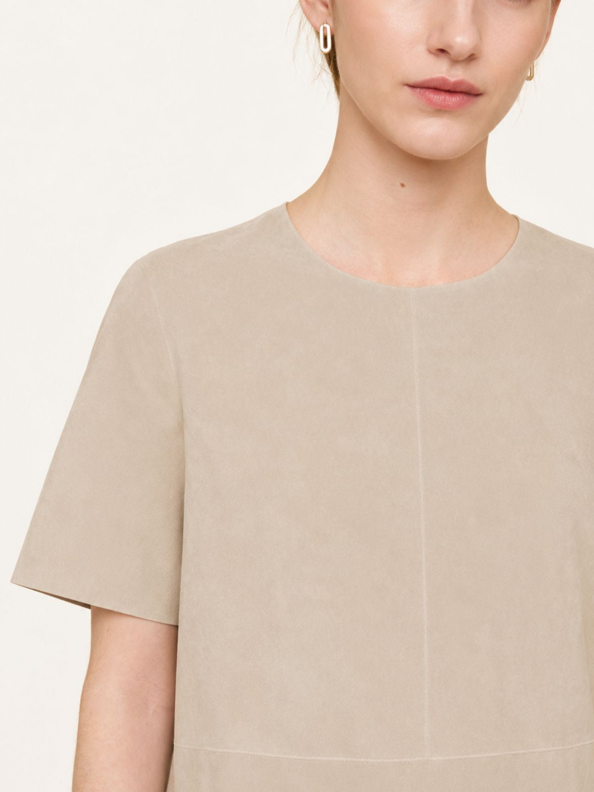 crop in of woman wearing cream suede t shirt top and cream skirt on white background by gushlow & cole