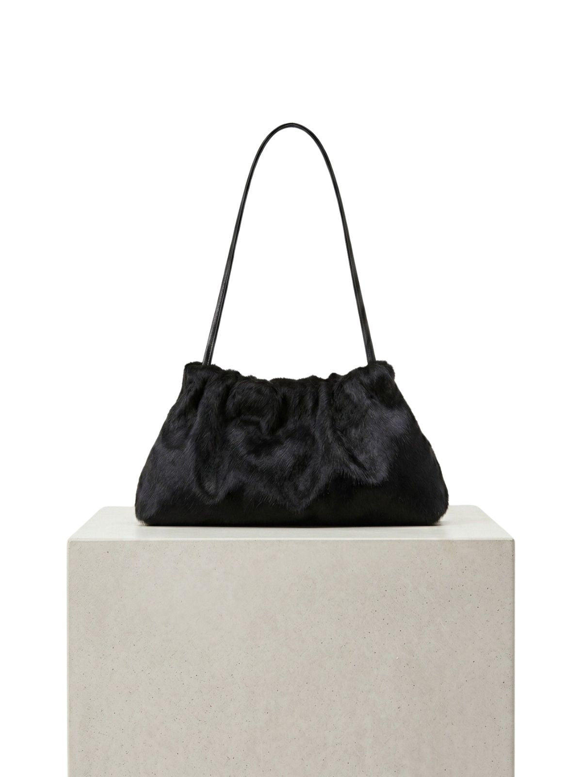 ghia small black shoulder bag made in calfskin on white background and plinth by gushlow & cole