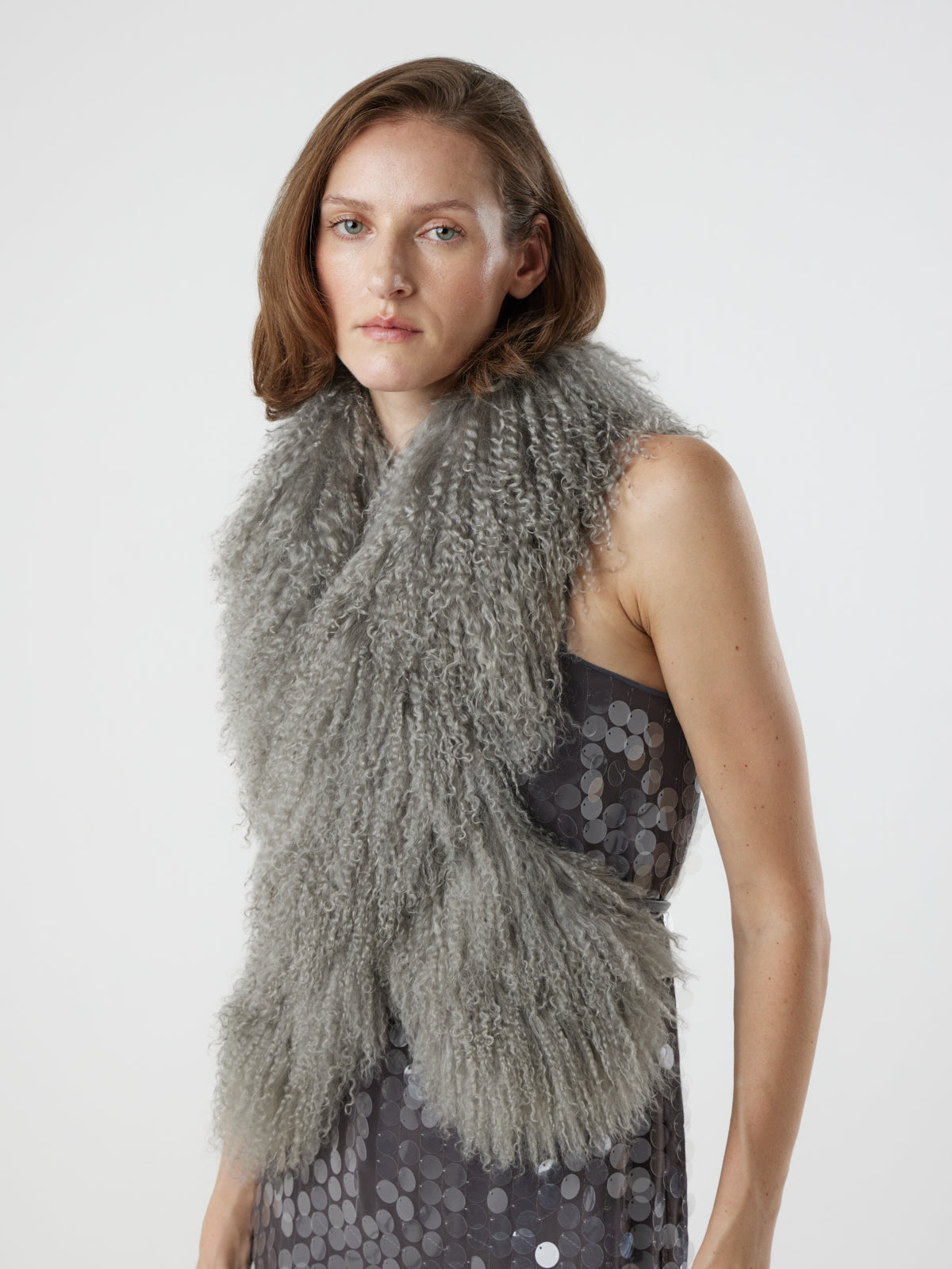 woman wearing grey Mongolian Shearling Shawl Scarf, styled crossed over, by gushlow & cole on white background