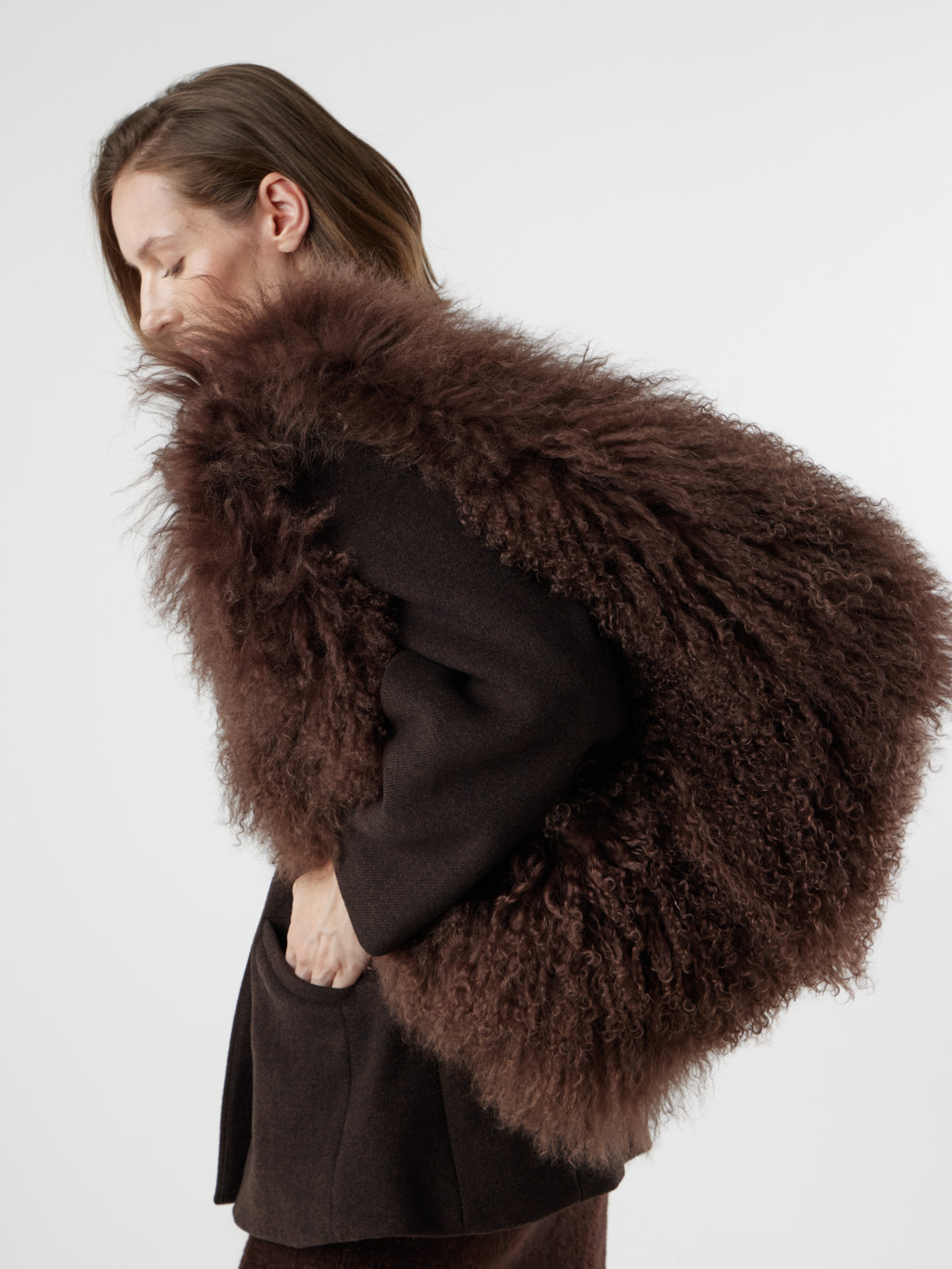 Woman wearing Large Brown Mongolian Shearling Shoulder Bag over shoulder by gushlow & cole on white background