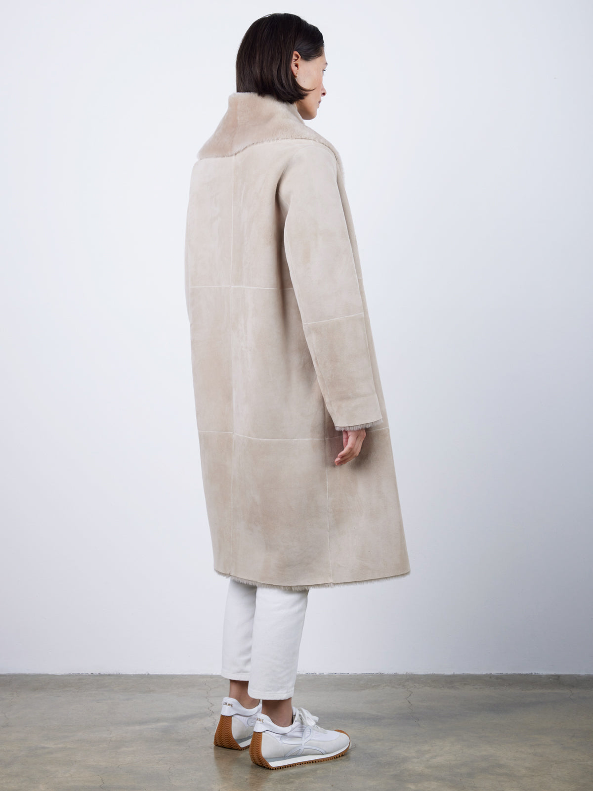 back view of woman wearing merino shearling shawl collar coat blanket shawl coat by gushlow & cole