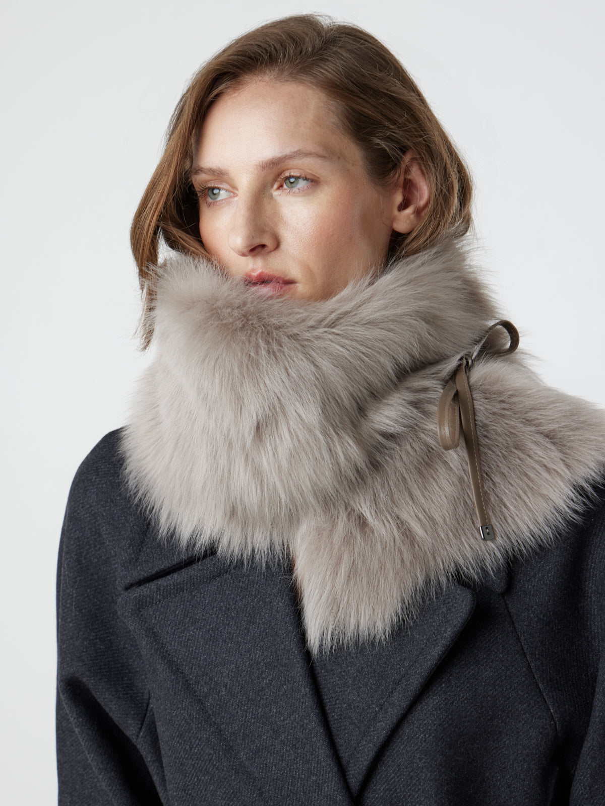 woman wearing taupe Shearling Shawl Scarf with nappa leather ties, styled as a snood, by gushlow & cole on white background