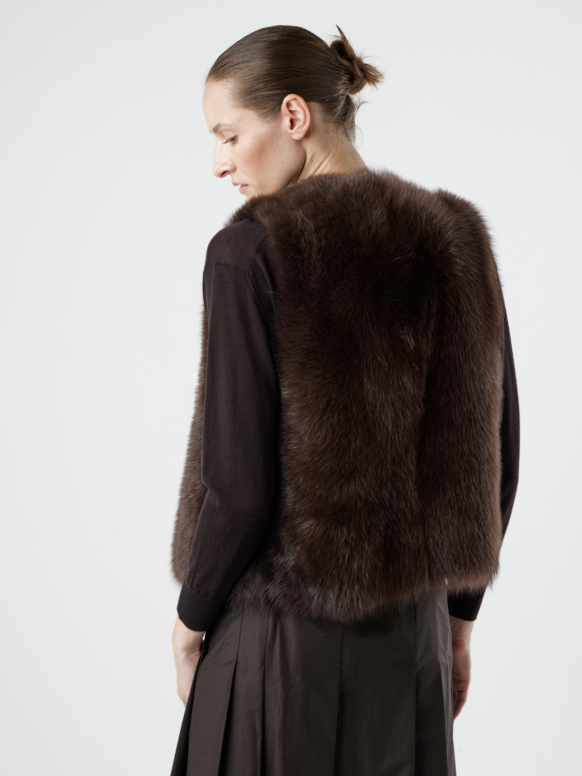 back view of woman wearing Two Button Brown Shearling Vest by Gushlow & Cole over brown jumper on white background