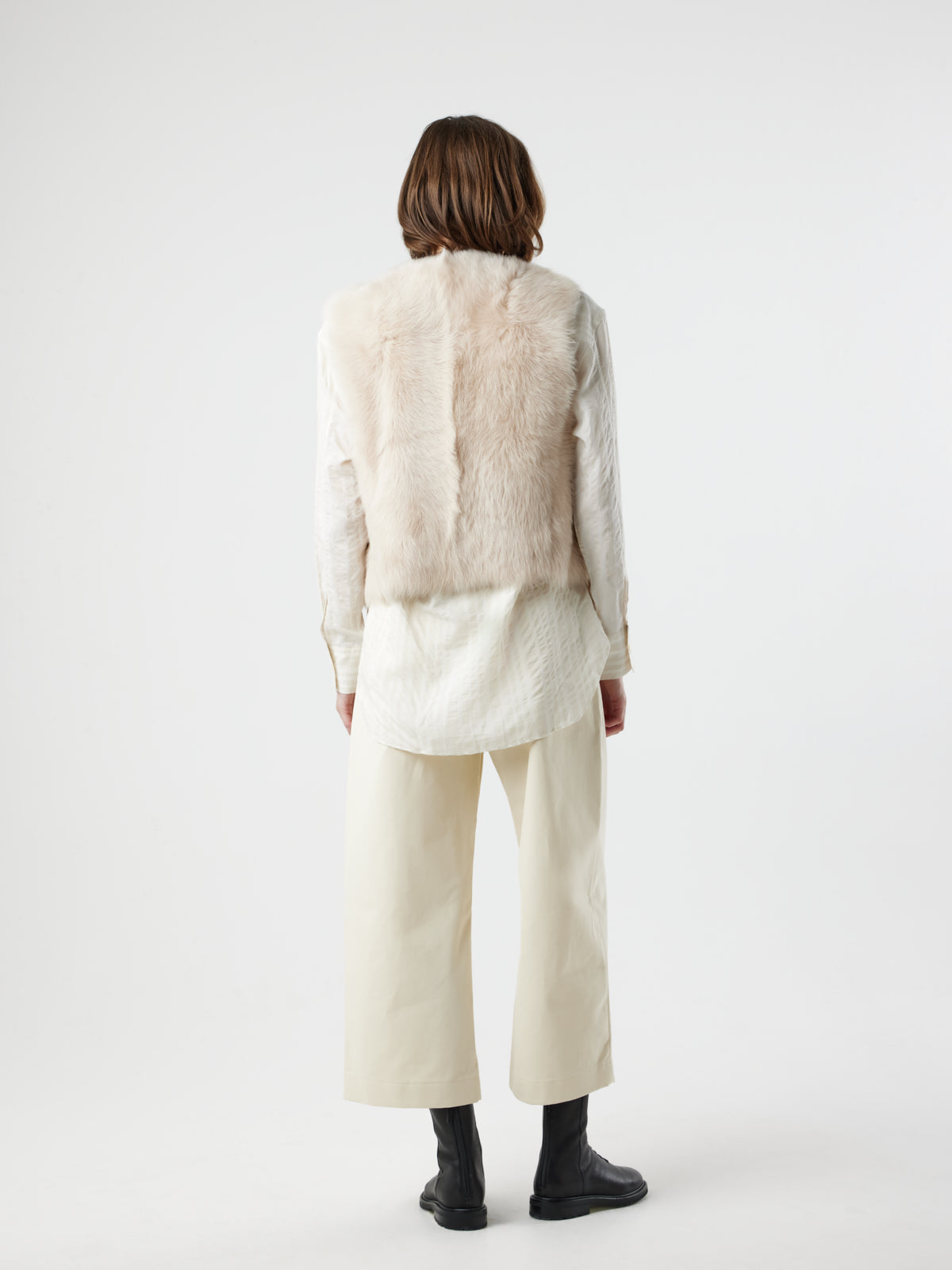 back view of woman wearing Two Button Cream Shearling Vest by gushlow & cole on white background