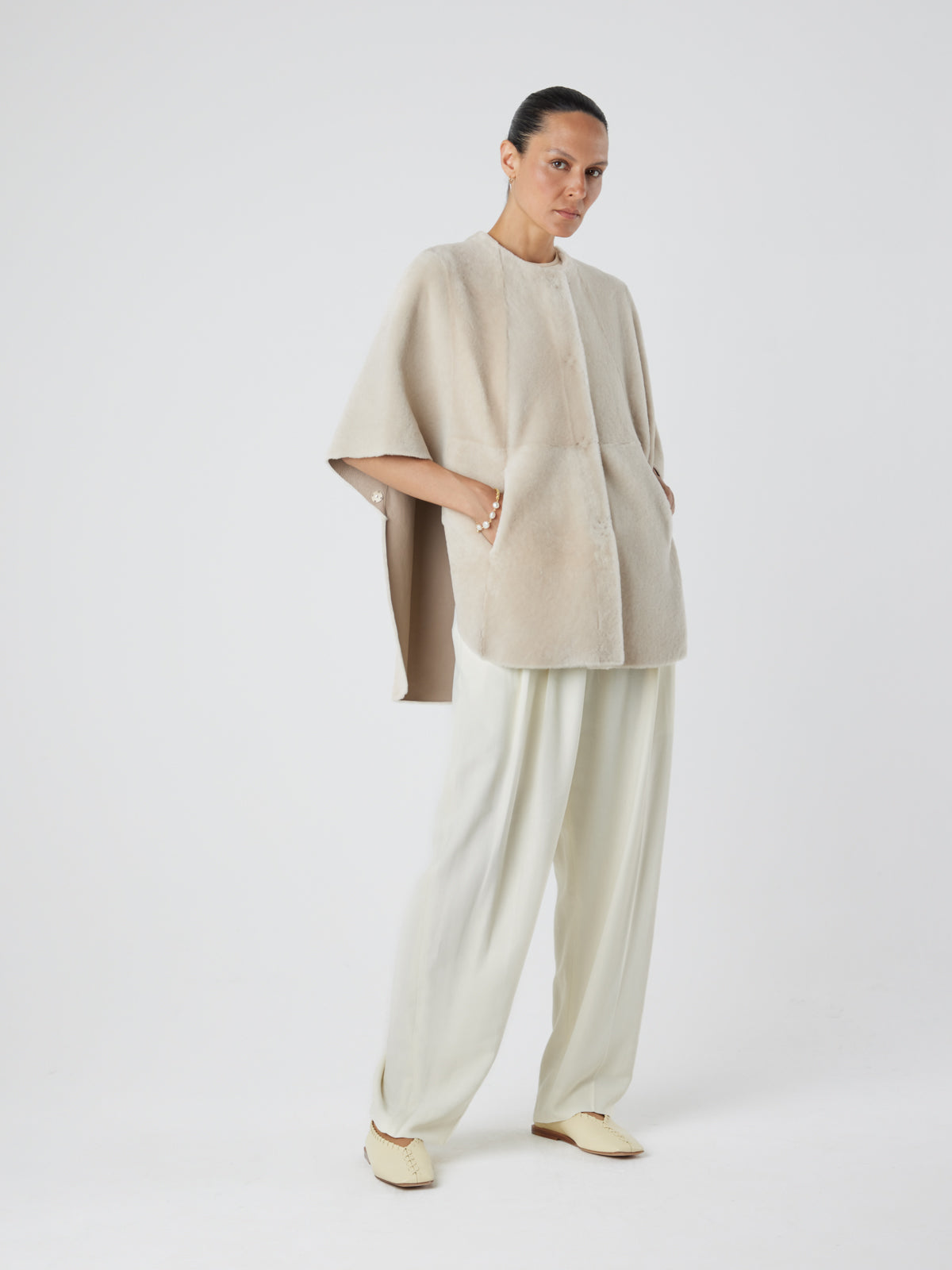 White Collarless Shearling Cape | Womens | Gushlow & Cole- model full length hands in pockets