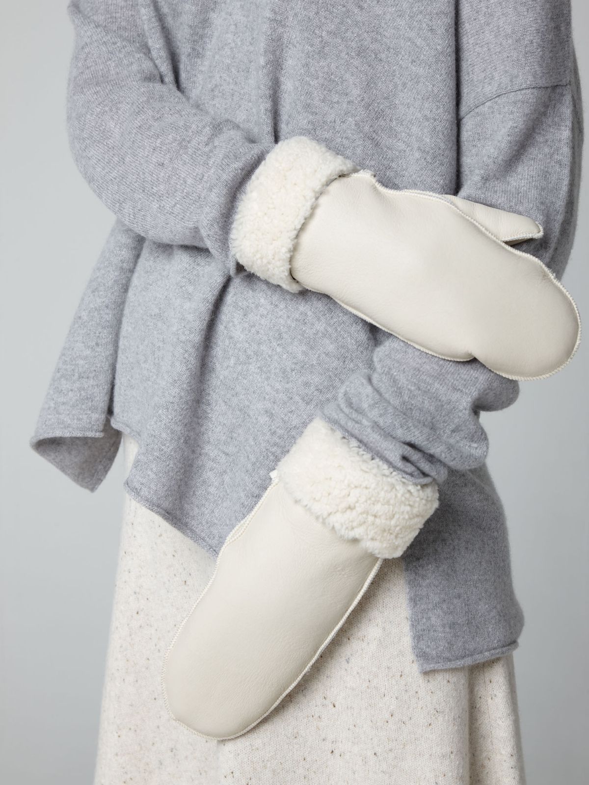 womans hands on white background wearing white full palm shearling mittens by Gushlow & Cole
