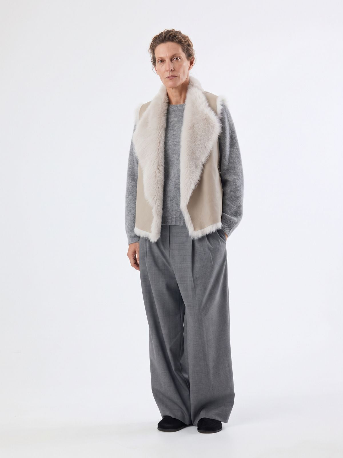 woman wearing white shearling and hand knit gilet by gushlow & cole