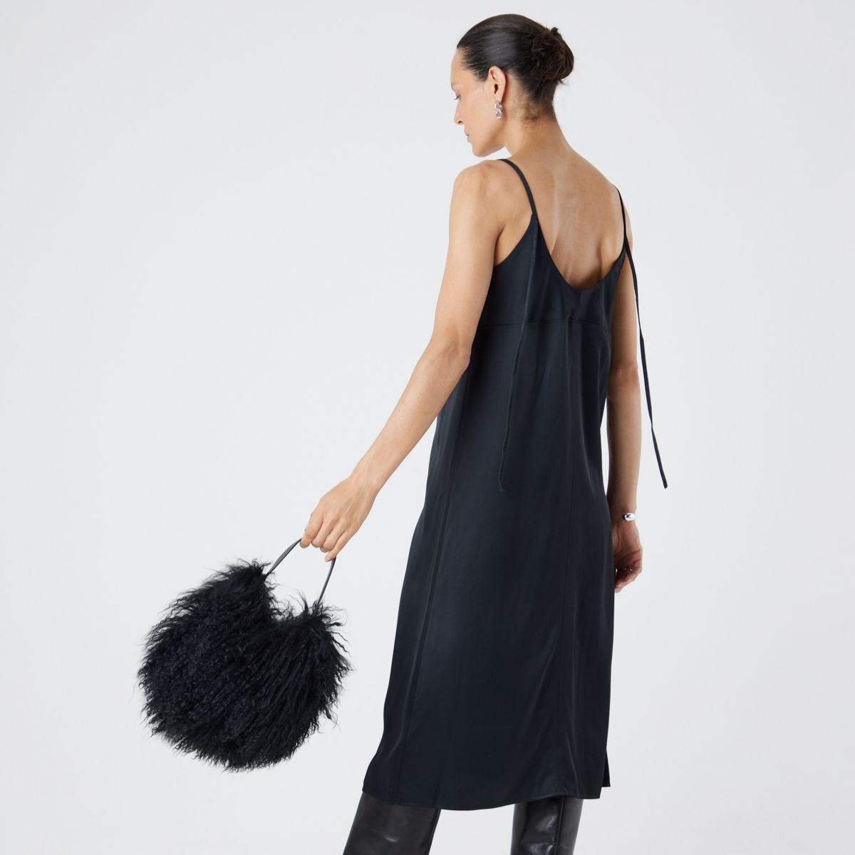 woman holding black mongolian shearling saddle bag by gushlow & cole