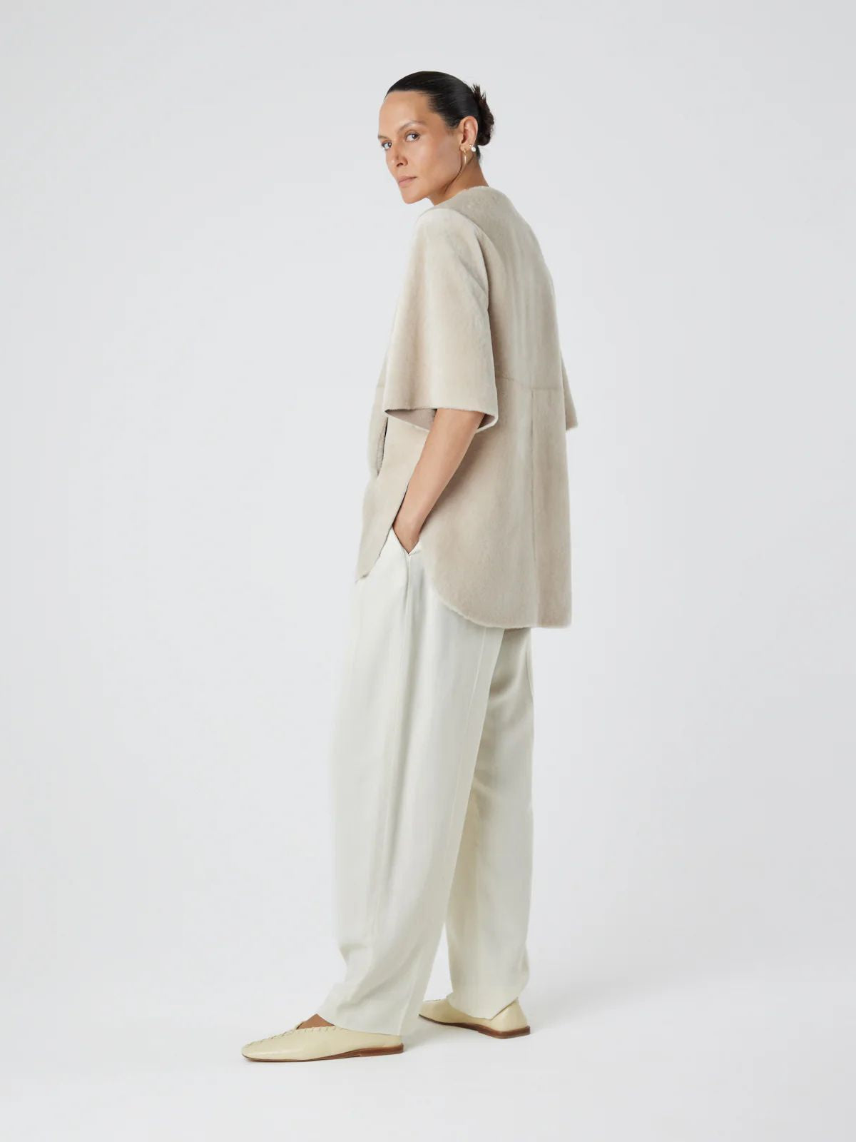 woman wearing cream cape jacket by gushlow & cole on white background
