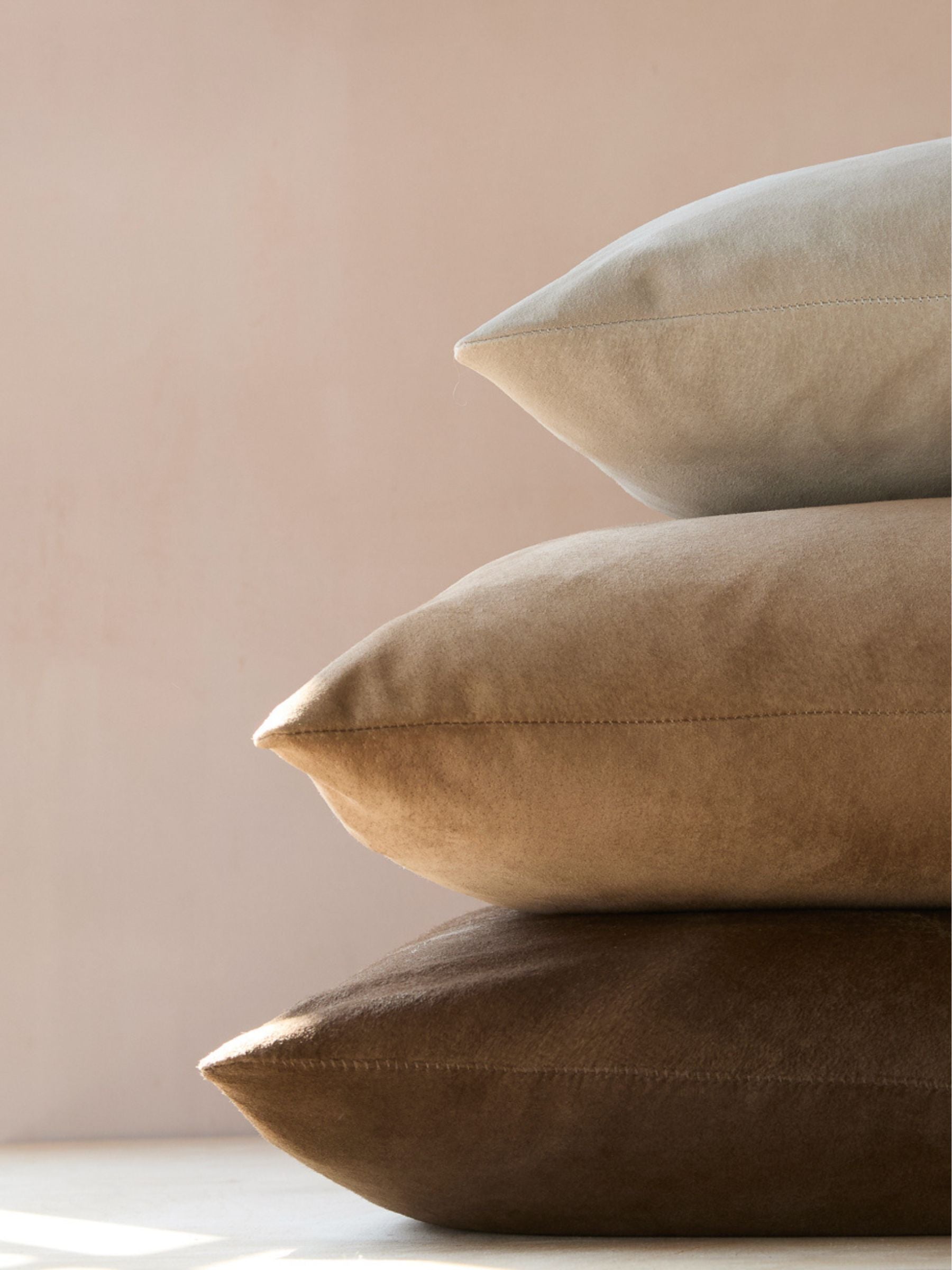 stack of cream suede cushion, camel suede cushion and brown suede cushion - luxury shearling and leather homeware gushlow & cole