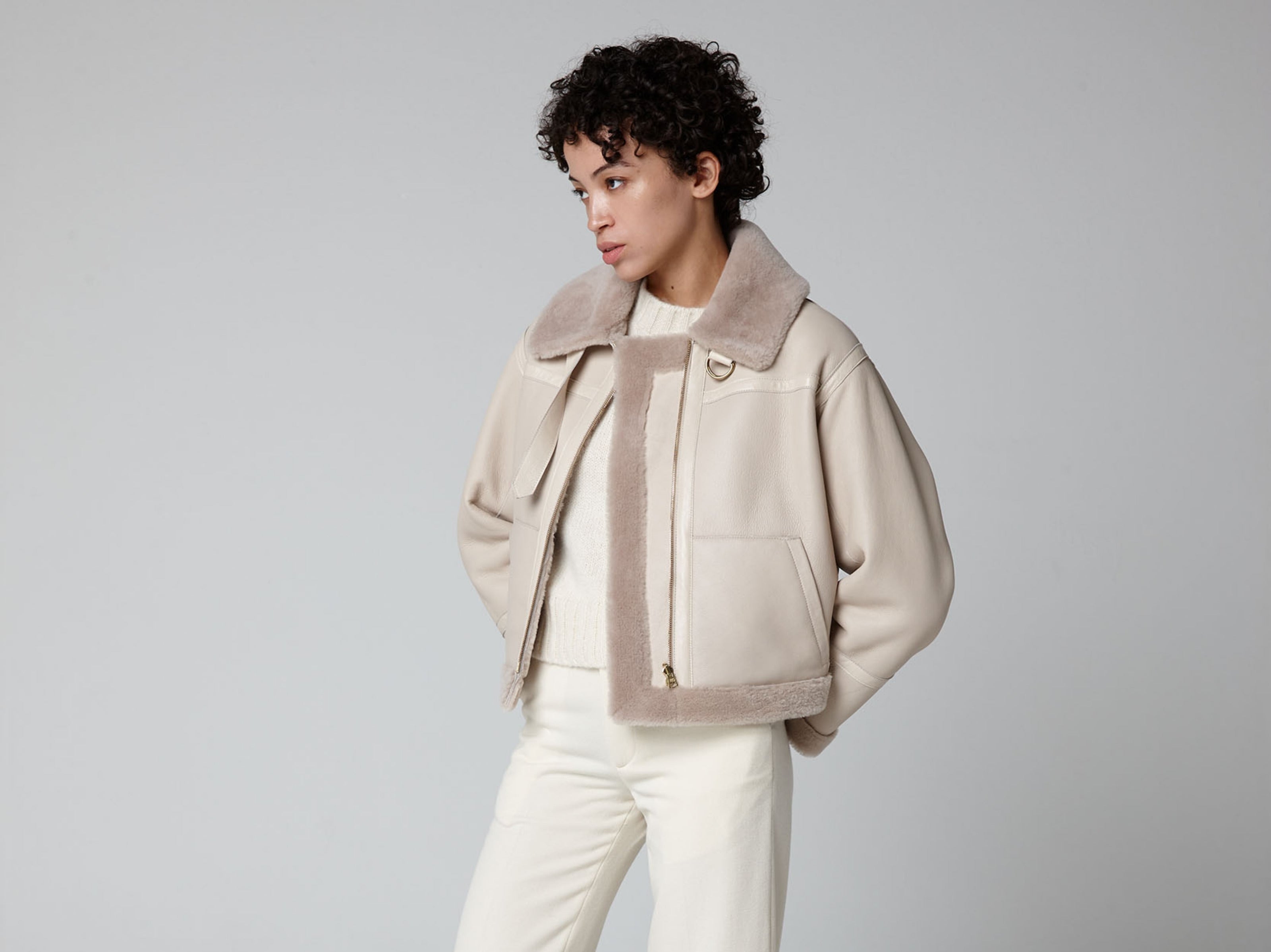 woman wearing shearling avaitor jacket in ecru by british shearling brand gushlow & cole