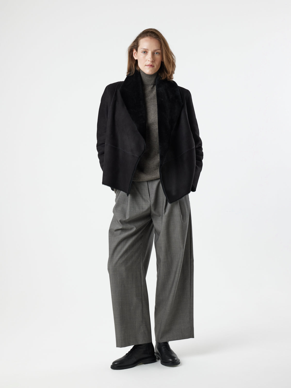 woman wearing Black Blanket Shawl Shearling Jacket by gushlow & cole on white background with hands in pockets