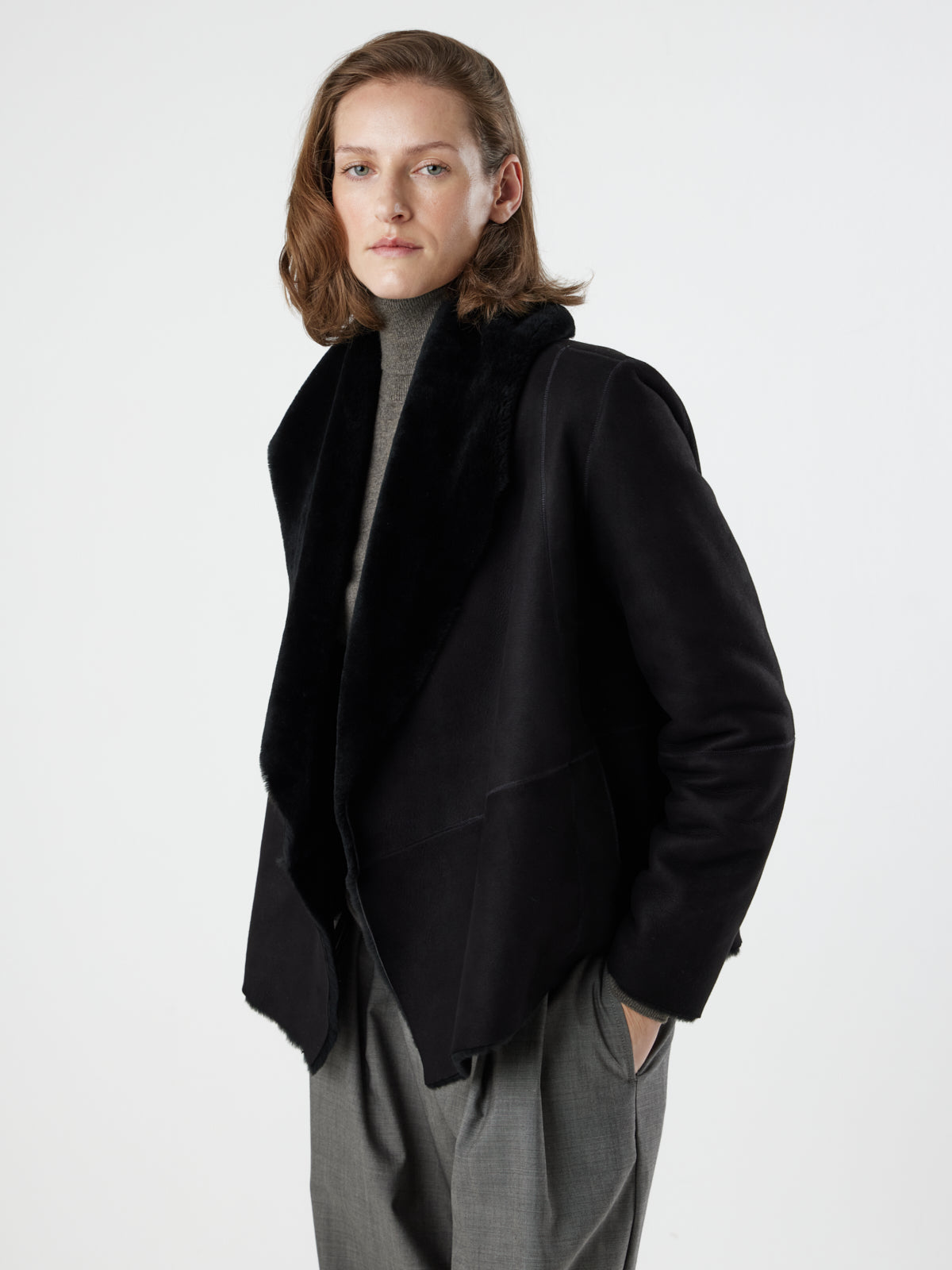 woman wearing Black Blanket Shawl Shearling Jacket by gushlow & cole on white background with hands in pockets
