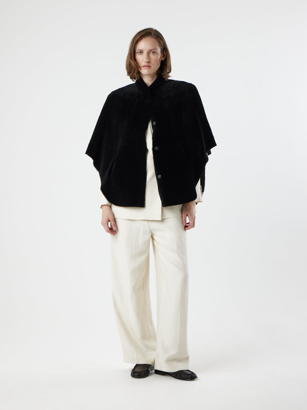 woman wearing Black Shearling Cape Jacket in merino by gushlow & cole on white background