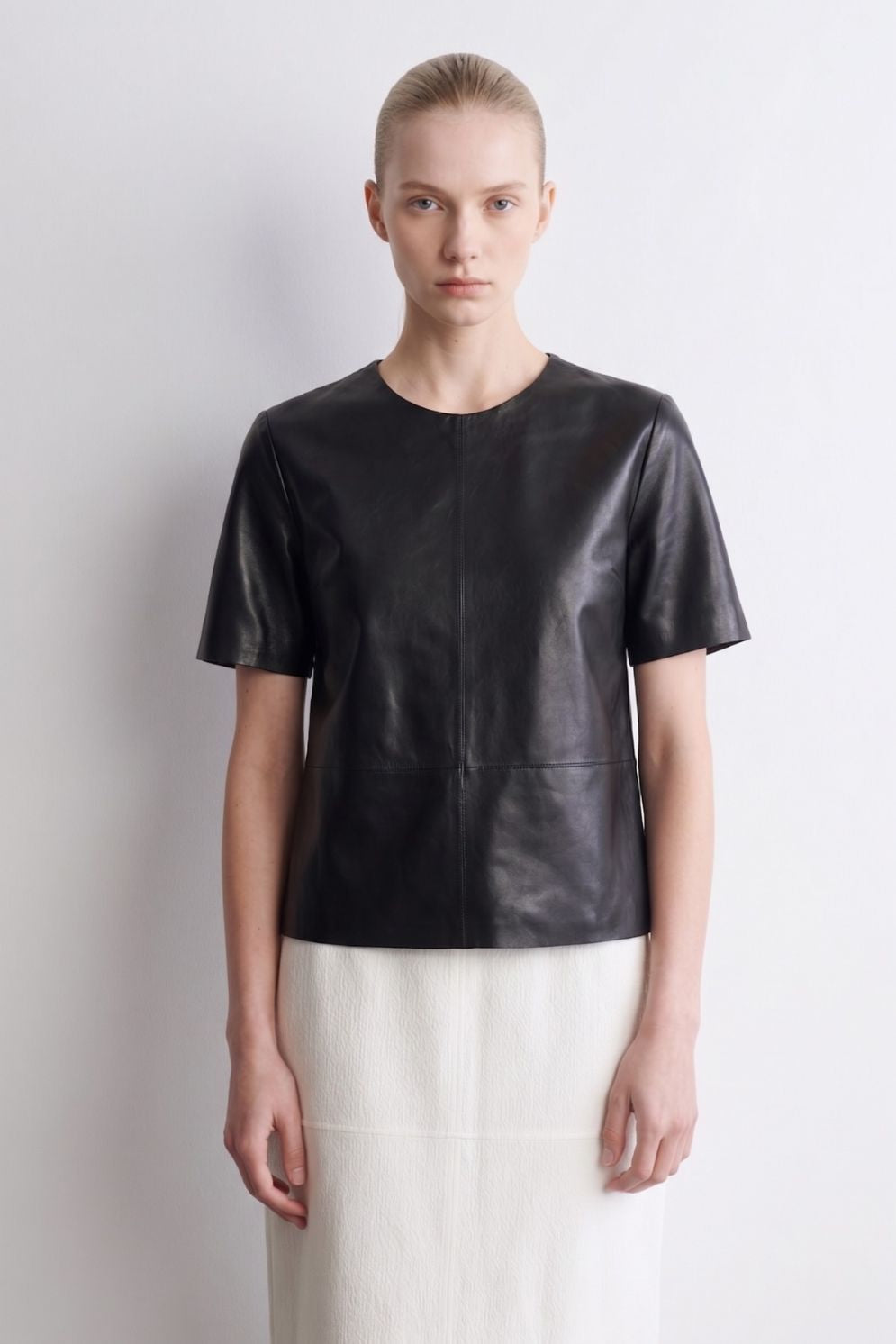 woman wearing black leather t shirt top on white background by gushlow & cole