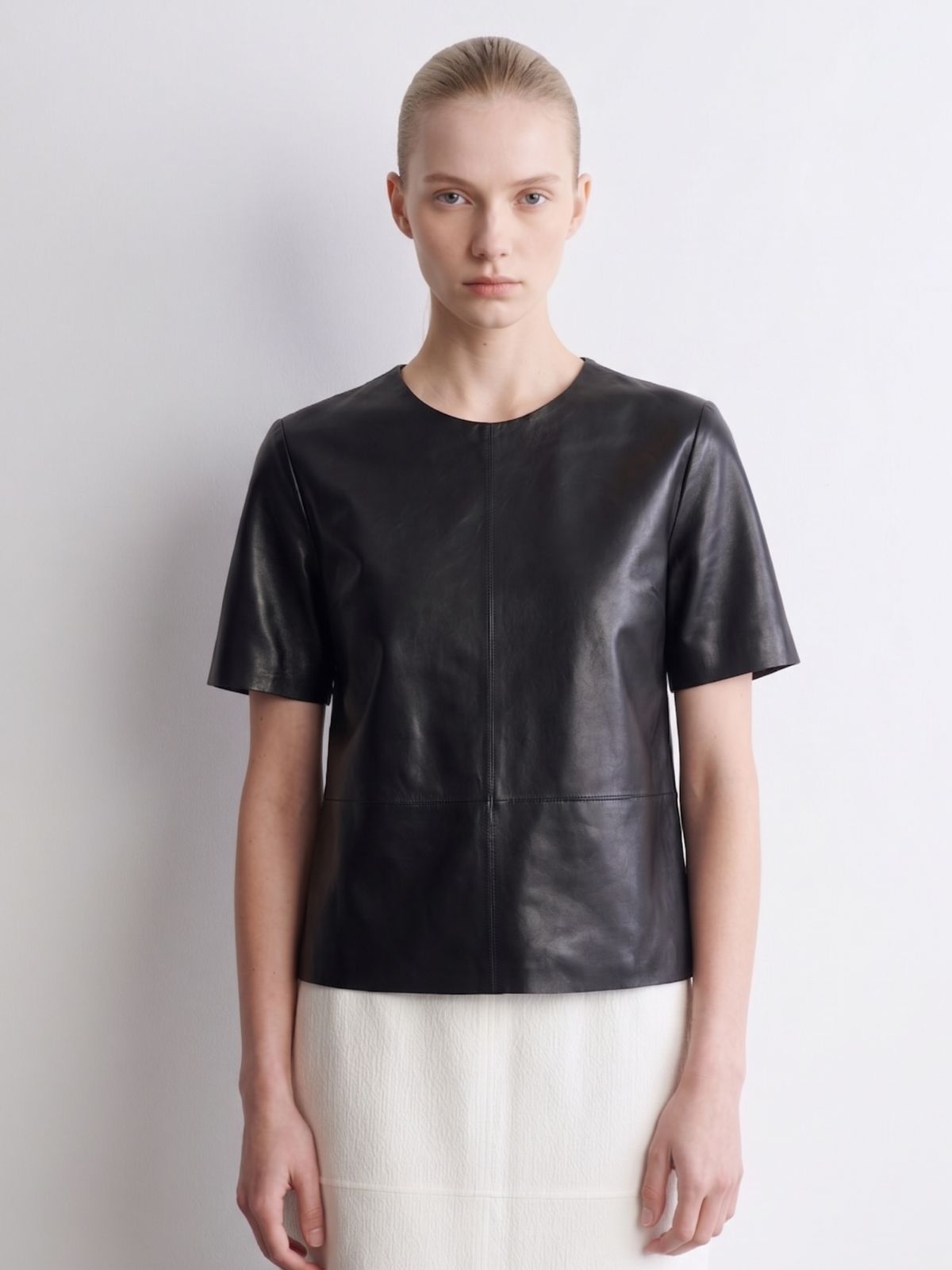 woman wearing black leather t shirt top on white background by gushlow & cole