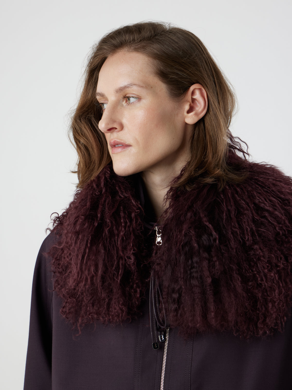 Woman wearing burgundy Mongolian Shearling Collar Scarf by gushlow & cole