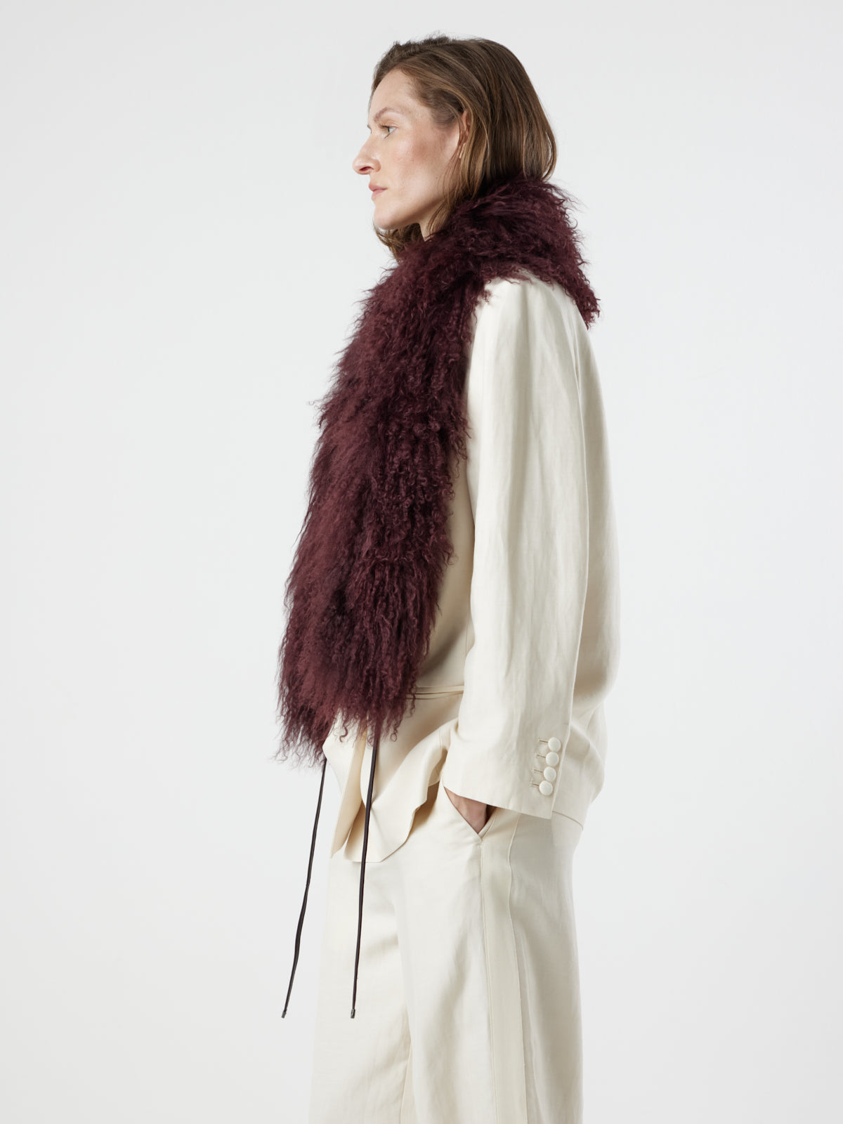 side view of woman wearing Burgundy Mongolian Shearling Shawl Scarf by gushlow & cole on white background