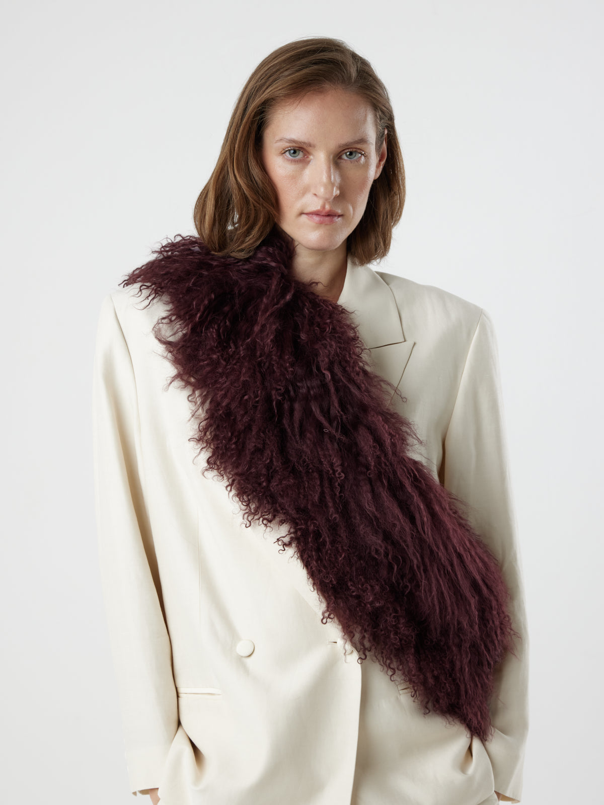 woman wearing Burgundy Mongolian Shearling Shawl Scarf, styled as a sash, by gushlow & cole on white background