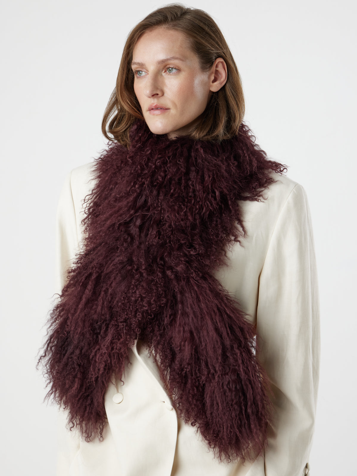 woman wearing Burgundy Mongolian Shearling Shawl Scarf, styled crossed over, by gushlow & cole on white background
