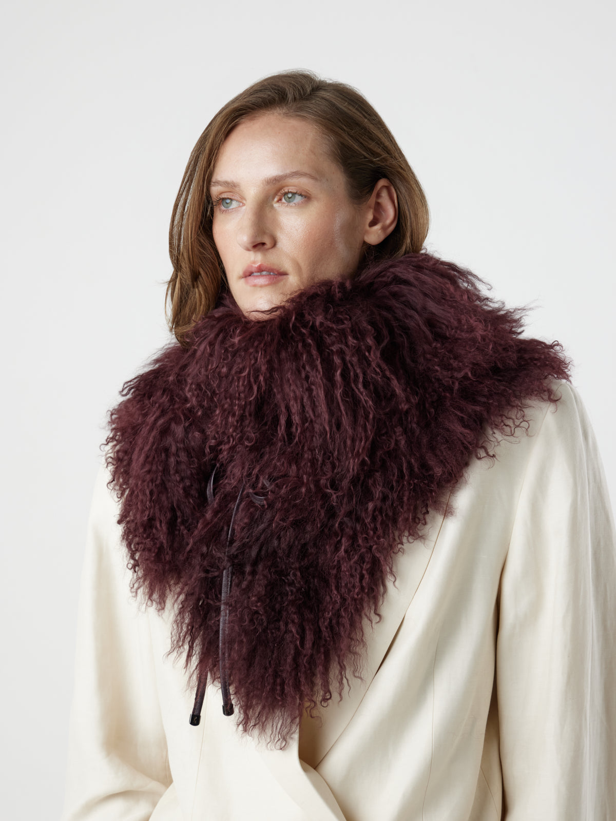 woman wearing Burgundy Mongolian Shearling Shawl Scarf, styled as a snood, by gushlow & cole on white background