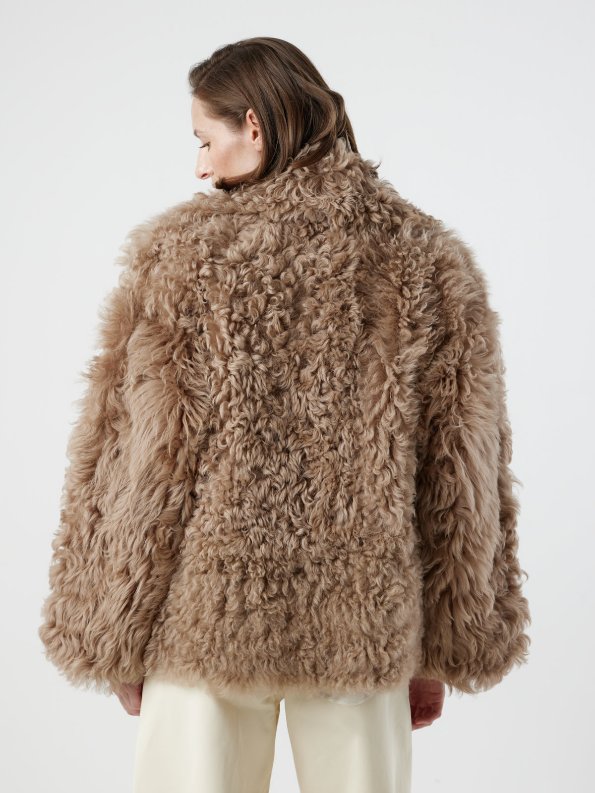 back view of woman wearing Camel Relaxed Fit Curly Shearling Jacket by gushlow & cole / curly sheepskin Jacket