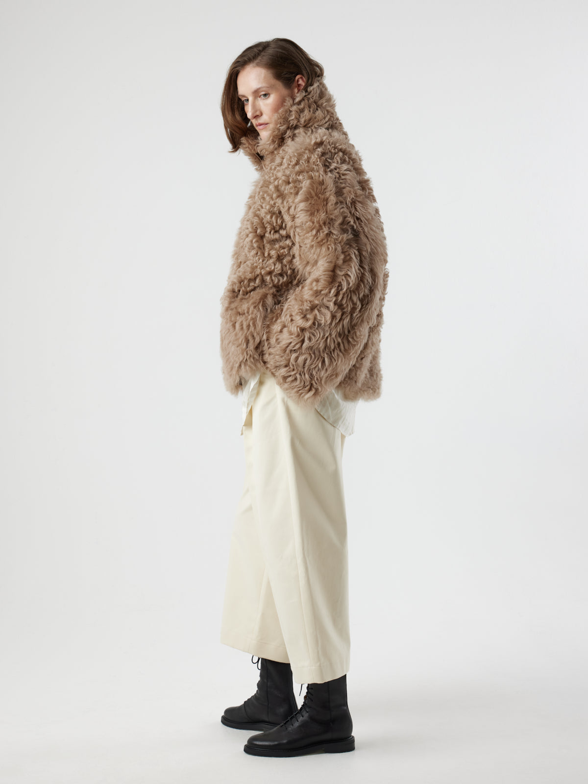 side view of woman wearing Camel Relaxed Fit Curly Shearling Jacket by gushlow & cole / curly sheepskin Jacket