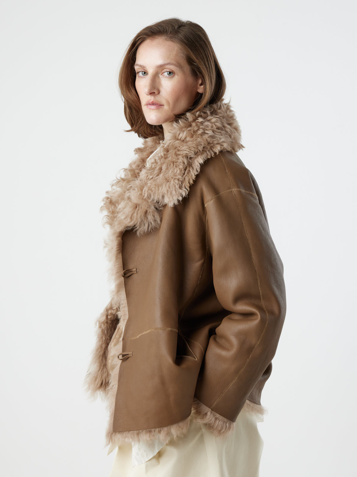 woman wearing reversed Camel Relaxed Fit Curly Shearling Jacket by gushlow & cole / curly sheepskin Jacket