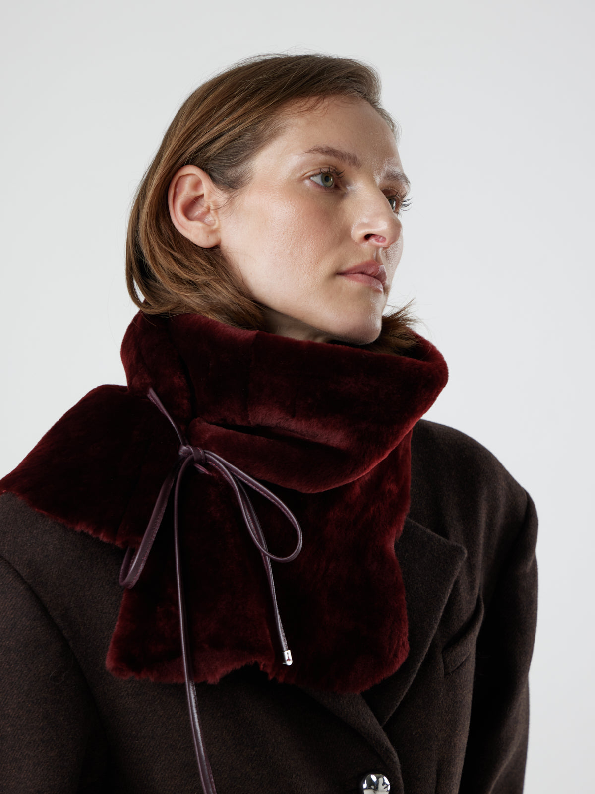 woman wearing cherry red shearling shawl scarf by gushlow & cole, tied as a snood
