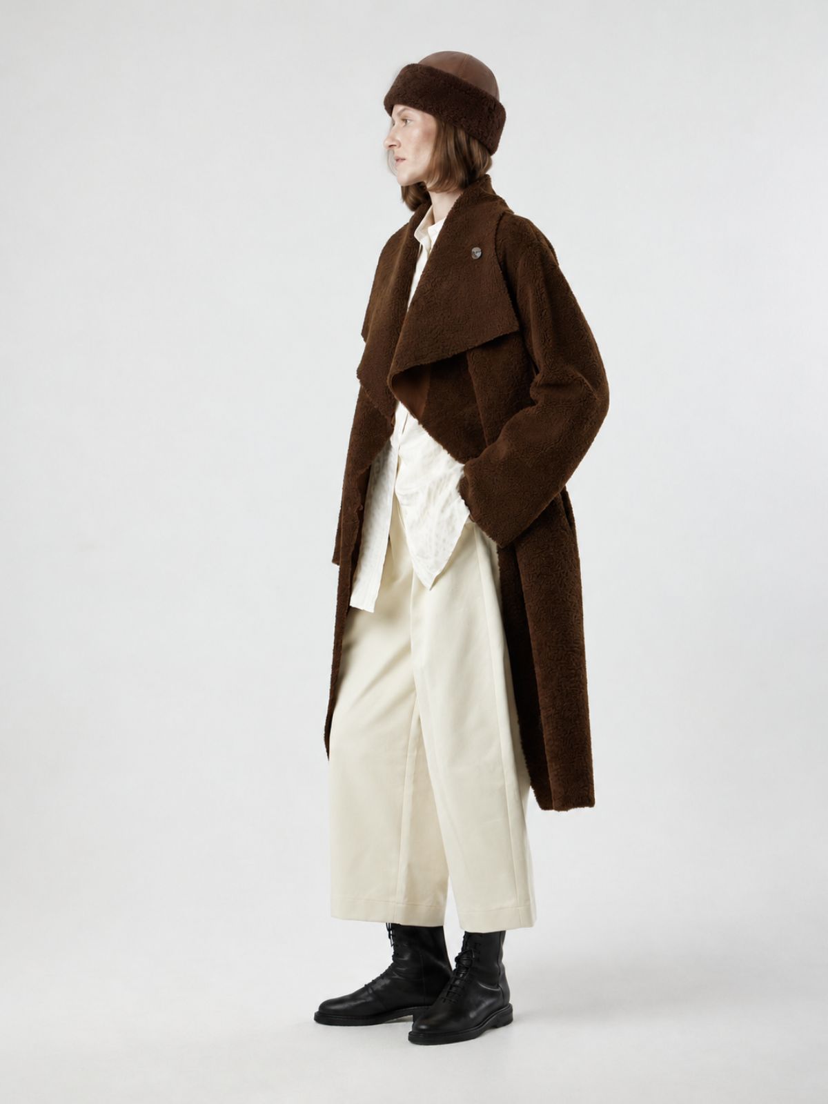 woman wearing chestnut brown chiswick shearling hat and brown shearling coat by gushlow & cole