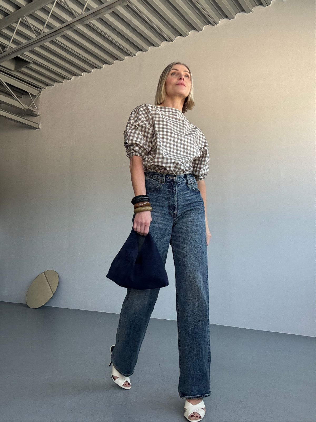 Yara Svalek walking and holding Clara Small Navy Blue Suede Shoulder Bag | Bags | Gushlow & Cole 