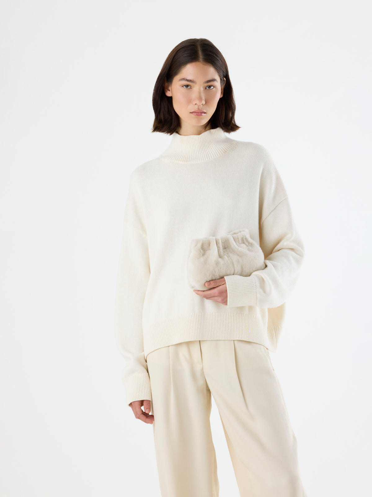 women holding Cream Mini Soft Shearling Clutch Bag by Gushlow & Cole