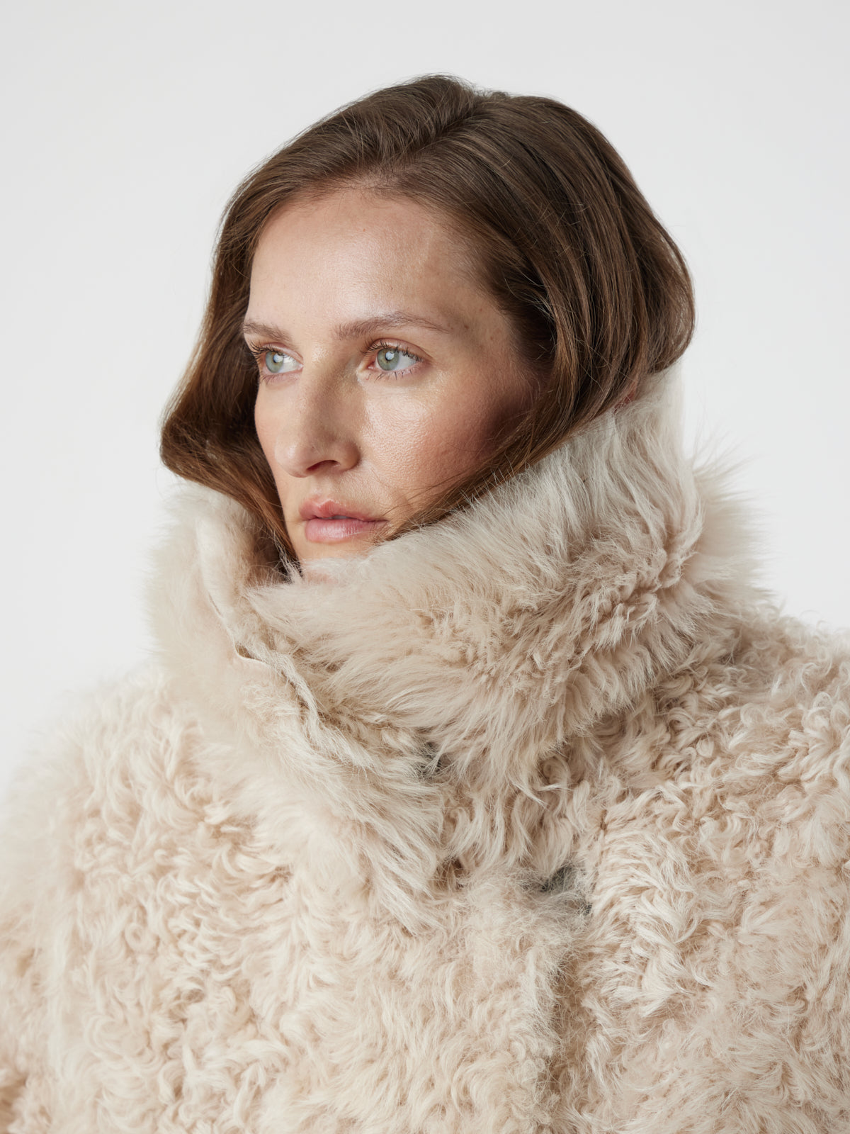 women on white background wearing Cream Relaxed Fit Curly Shearling Coat with collar done up by gushlow & cole 