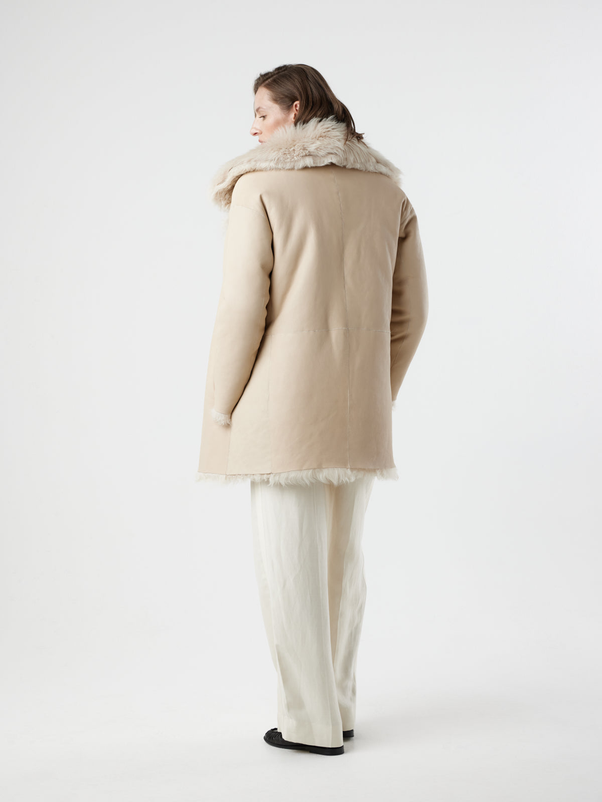 back view of women wearing reversed Cream Relaxed Fit Curly Shearling Coat by gushlow & cole