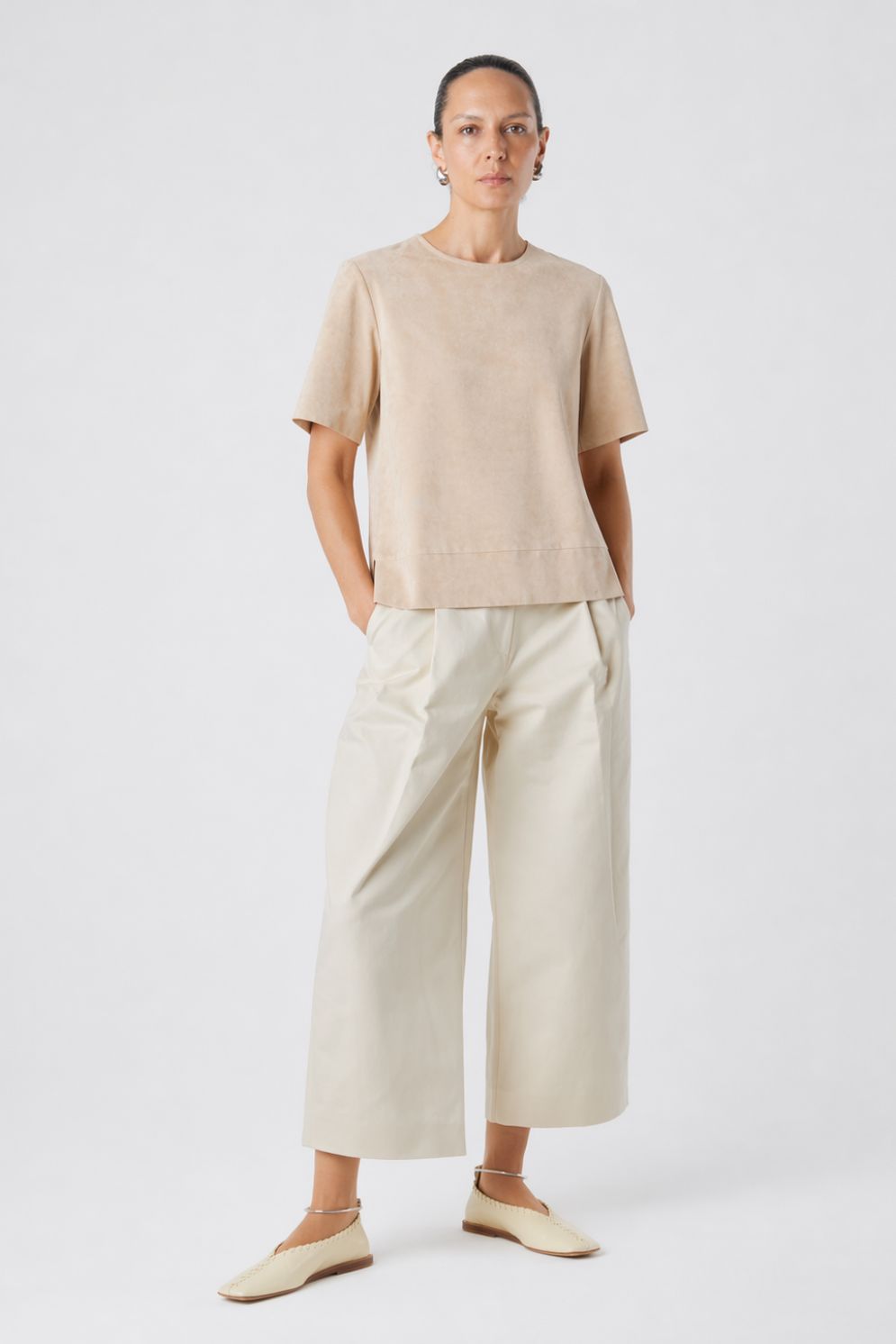 woman wearing cream suede t shirt top and cream leather trousers on white background by gushlow & cole