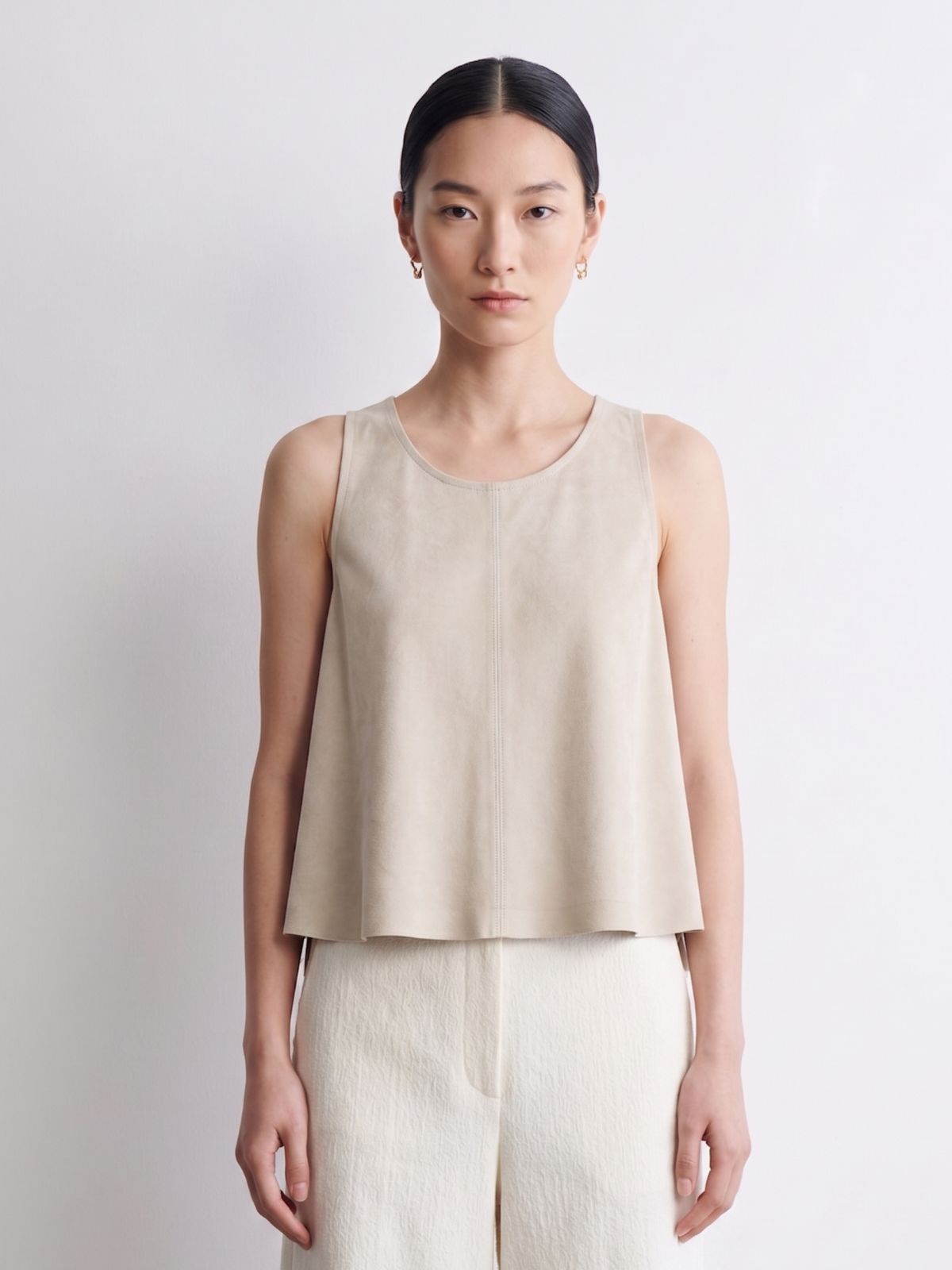 woman wearing cream suede vest top and cream trousers on white background by gushlow & cole