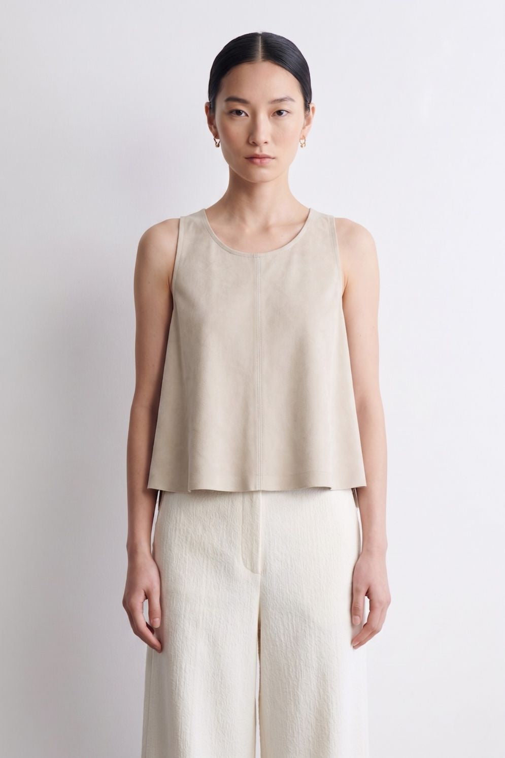 woman wearing cream suede vest top and cream trousers on white background by gushlow & cole