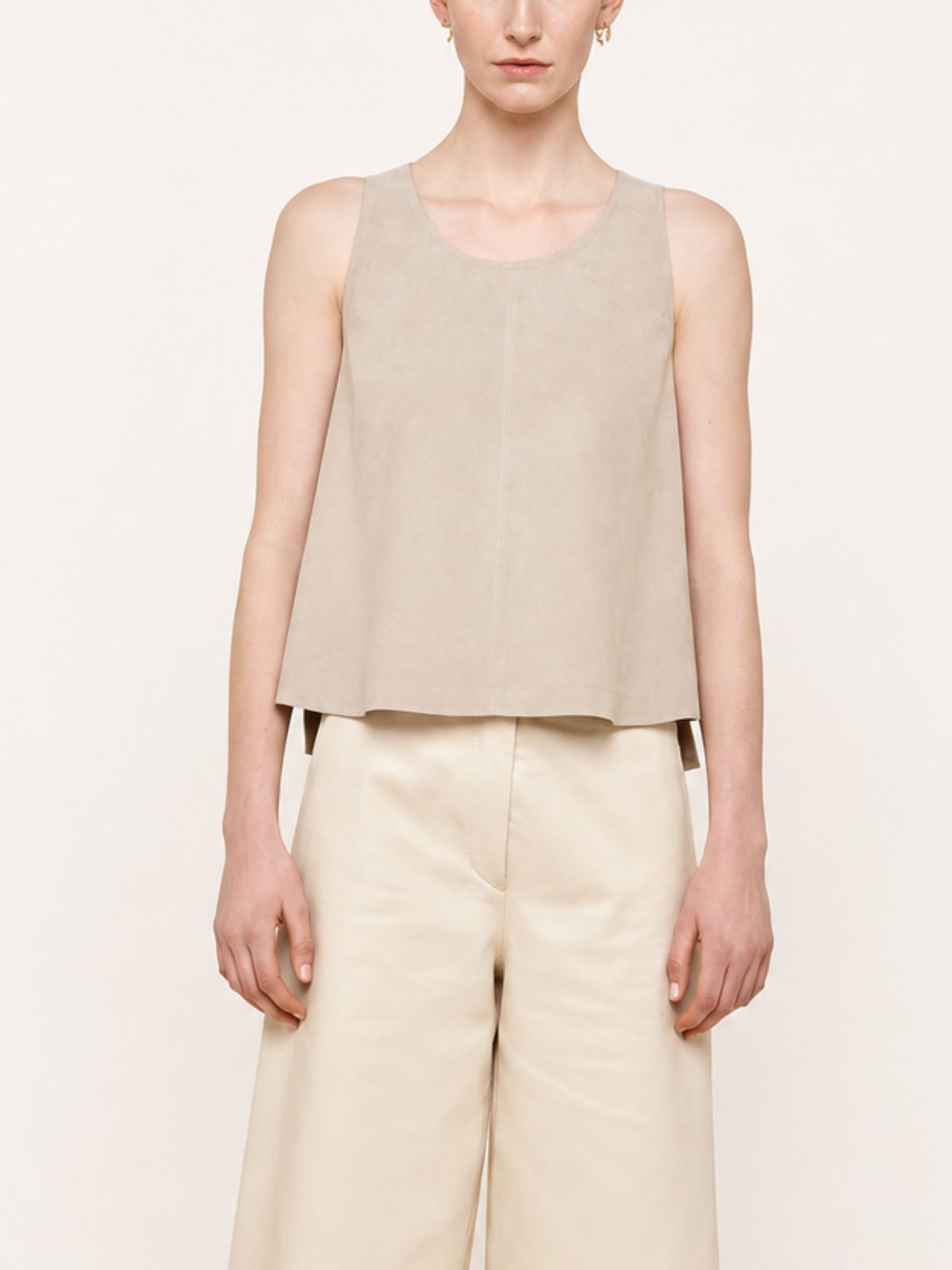 woman wearing cream suede vest top and cream leather trousers on white background by gushlow & cole