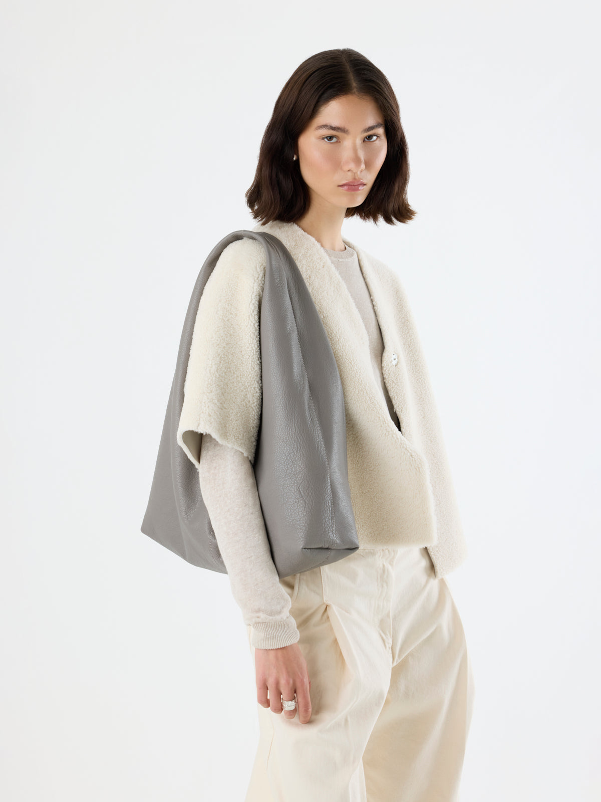 woman wearing Clara Large Leather Shoulder Bag in grey by gushlow & Cole over shoulder on white background
