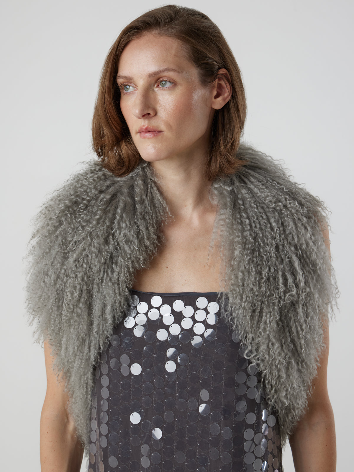 woman wearing grey Mongolian Shearling Shawl Scarf, styled as a shawl, by gushlow & cole on white background
