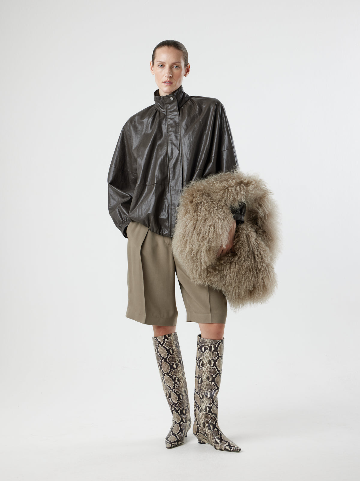Woman wearing Large Beige Mongolian Shearling Shoulder Bag over wrist by gushlow & cole on white background