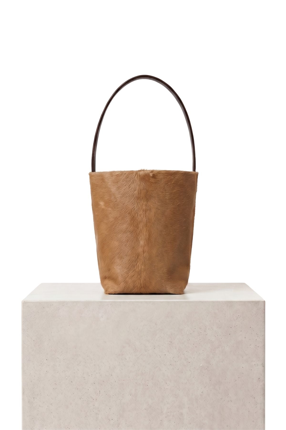 maye small camel bucket tote bag by gushlow & cole on plinth