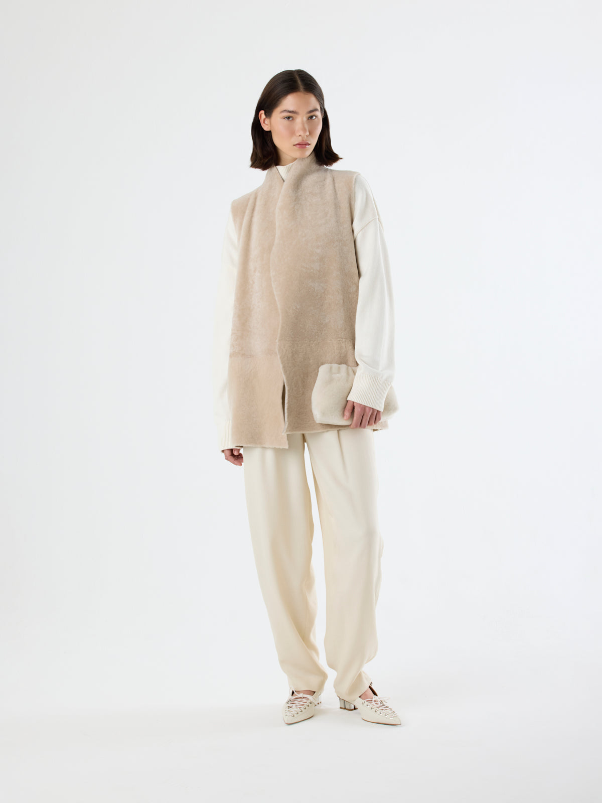 woman wearing cream longline shearling gilet on white background - luxury womens shearling gushlow & cole